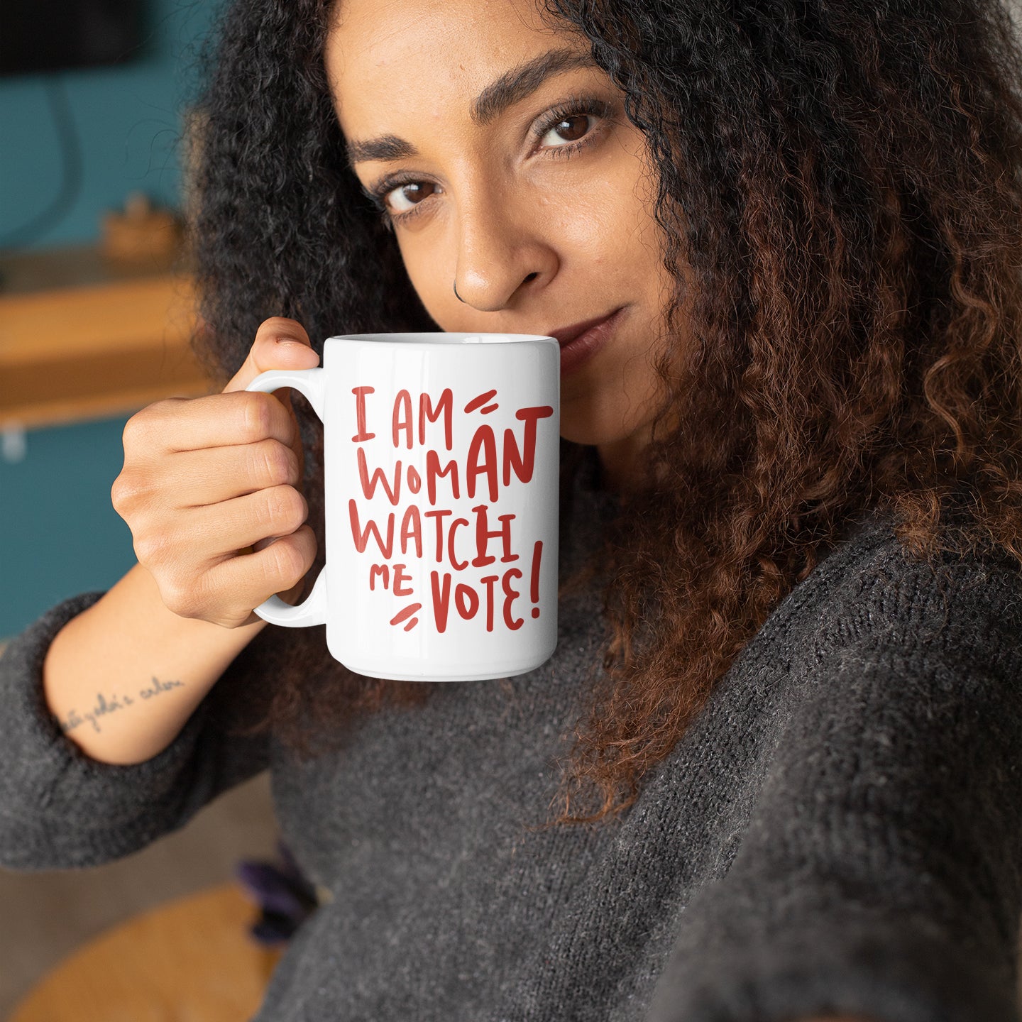 a woman holding a coffee mug with a message on it