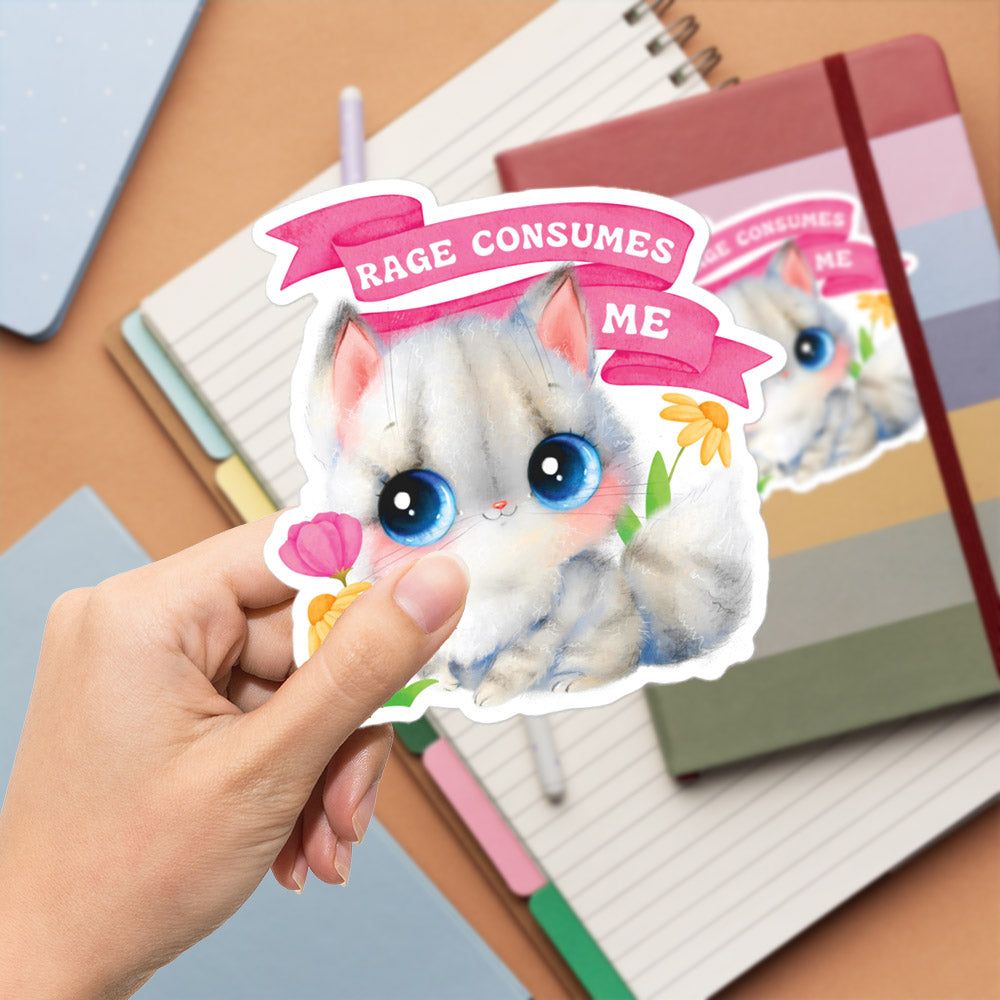 A hand is holding a sticker featuring a cute cat with a flower in its mouth, surrounded by a pink banner that says "RAGE CONSUMES ME".