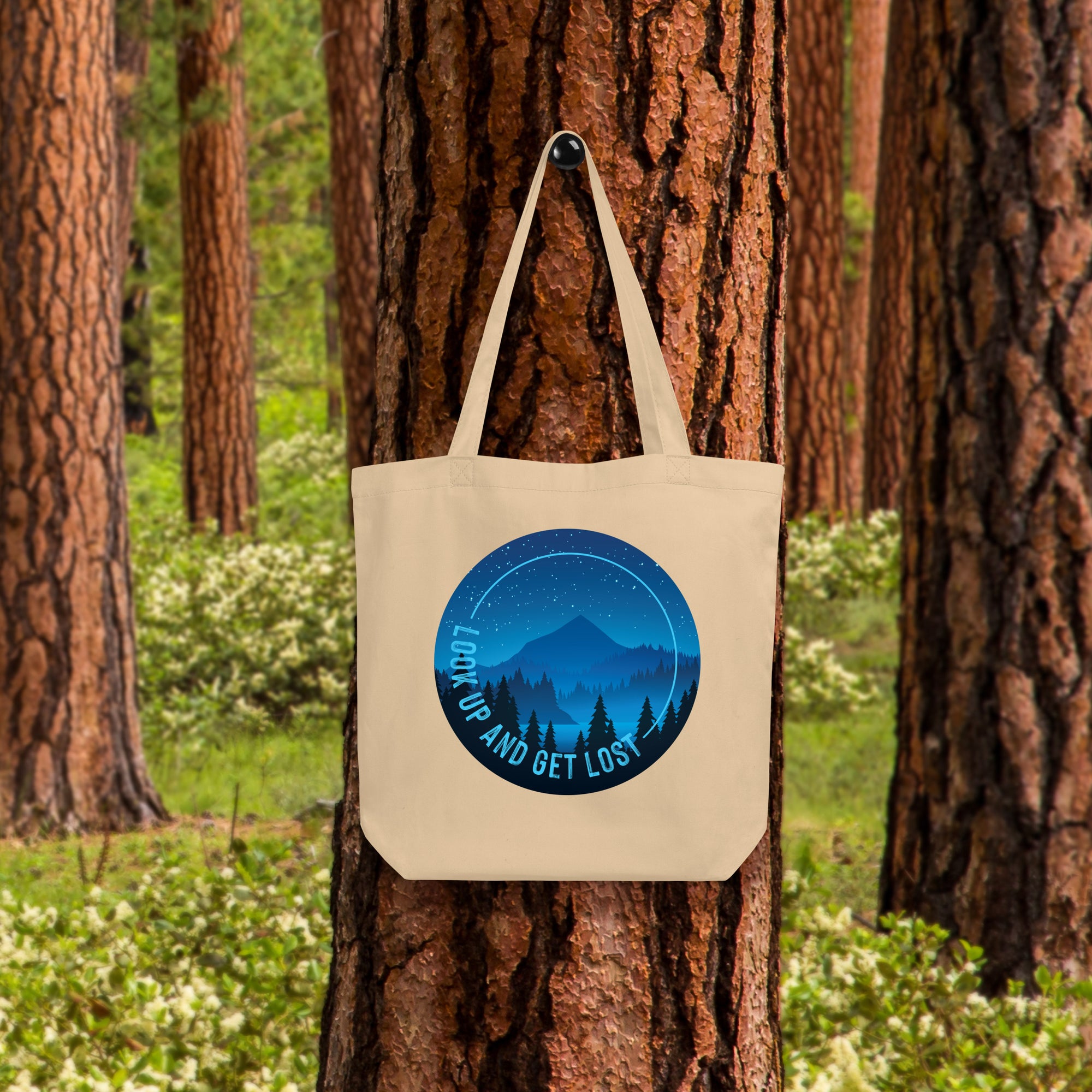 a tote bag hanging on a tree in a forest