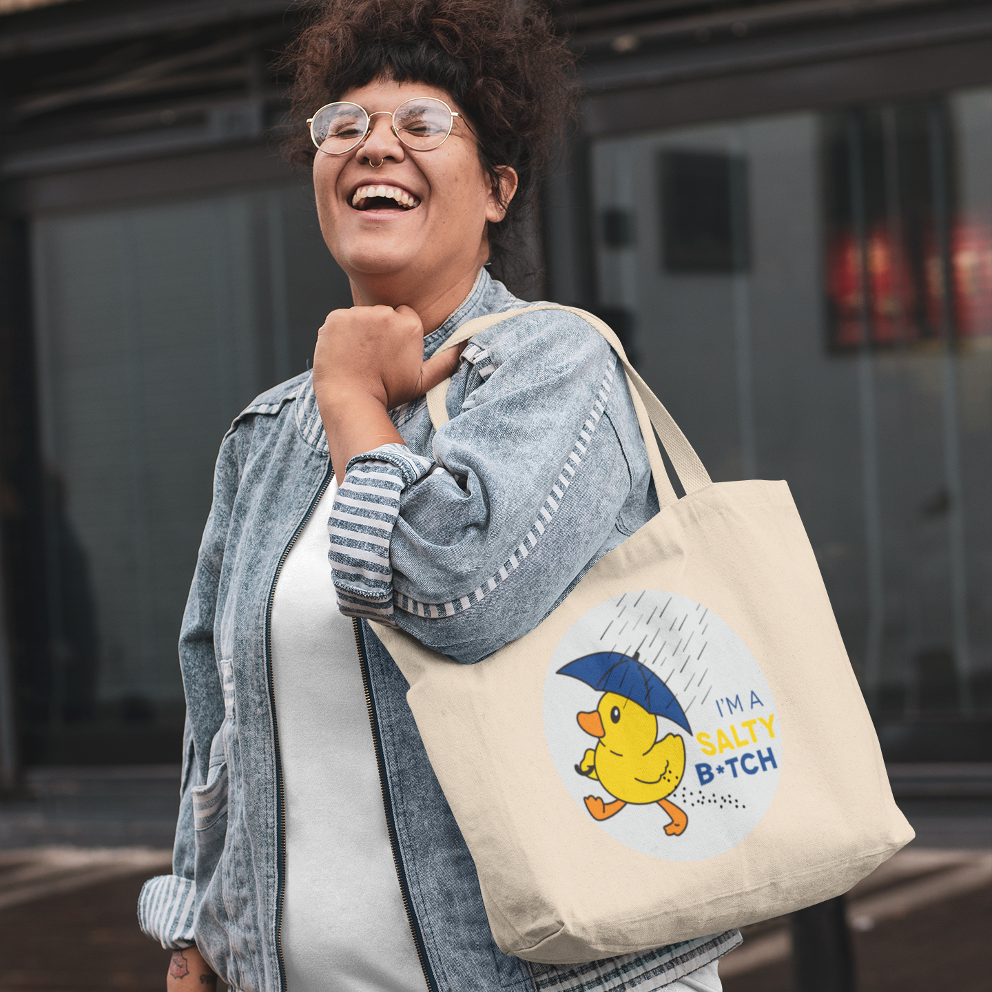 a woman carrying a tote bag and smiling