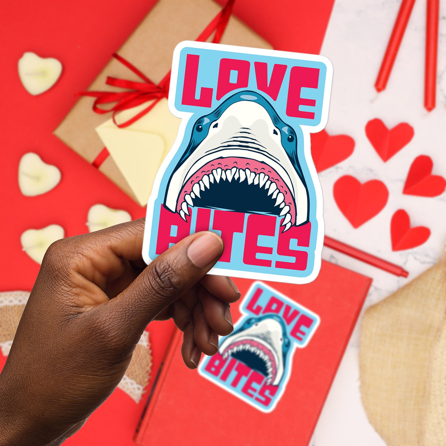 a hand holding a sticker with a shark on it