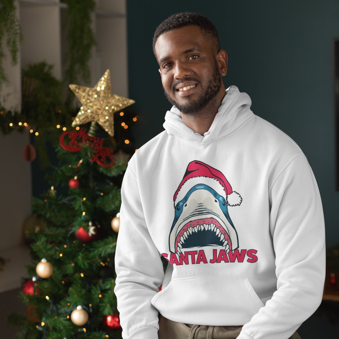 a man standing in front of a christmas tree