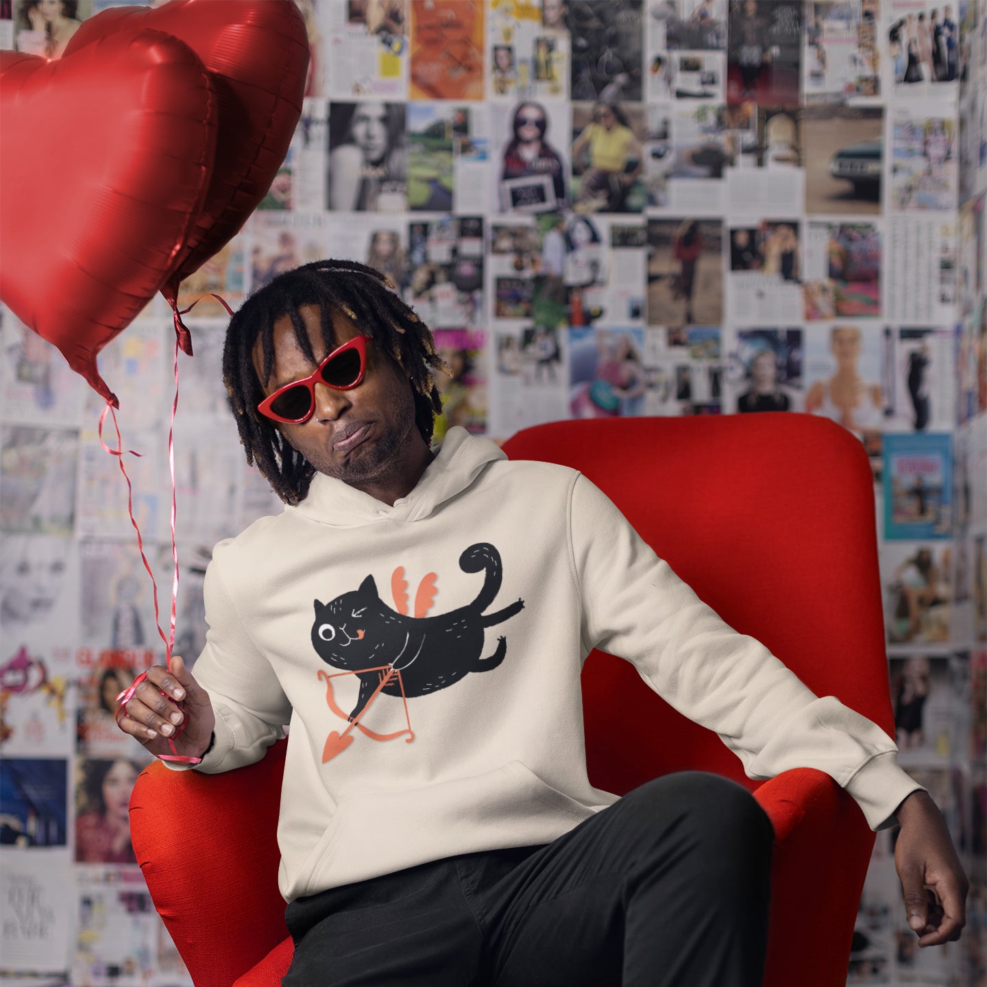 a man sitting in a red chair holding a heart shaped balloon