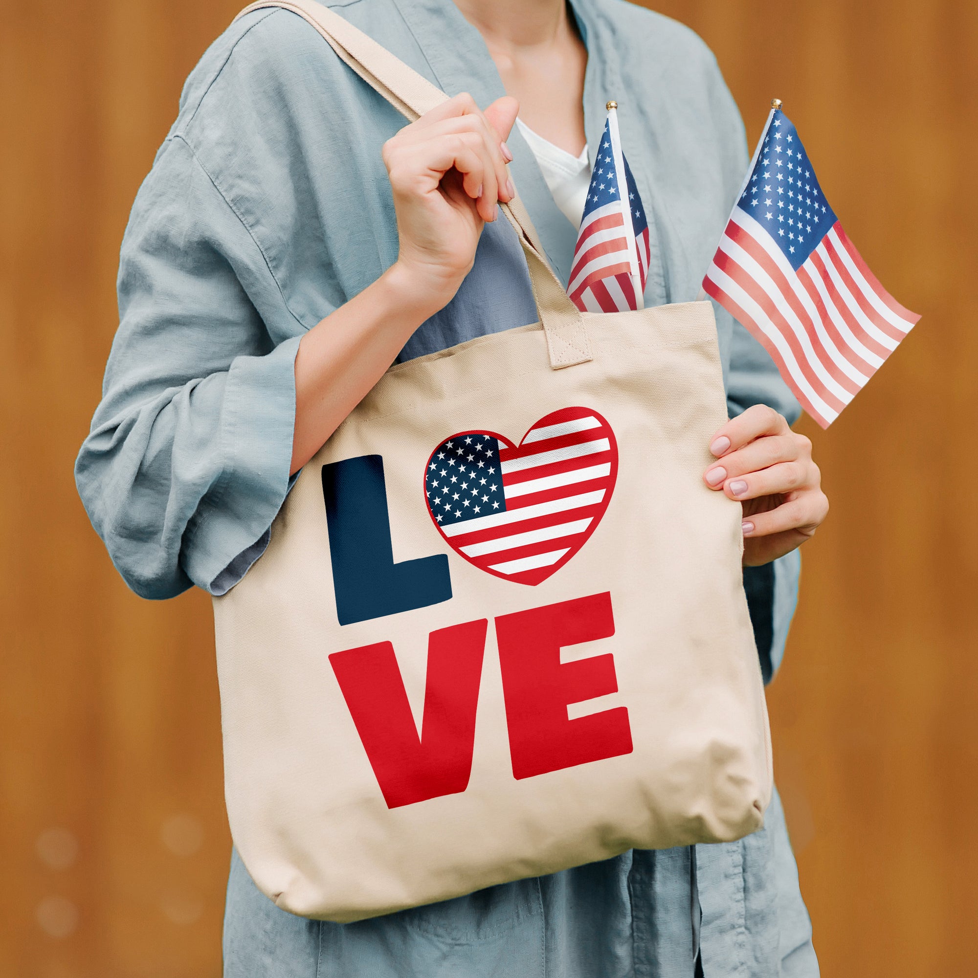 a woman holding a tote bag with an american flag on it