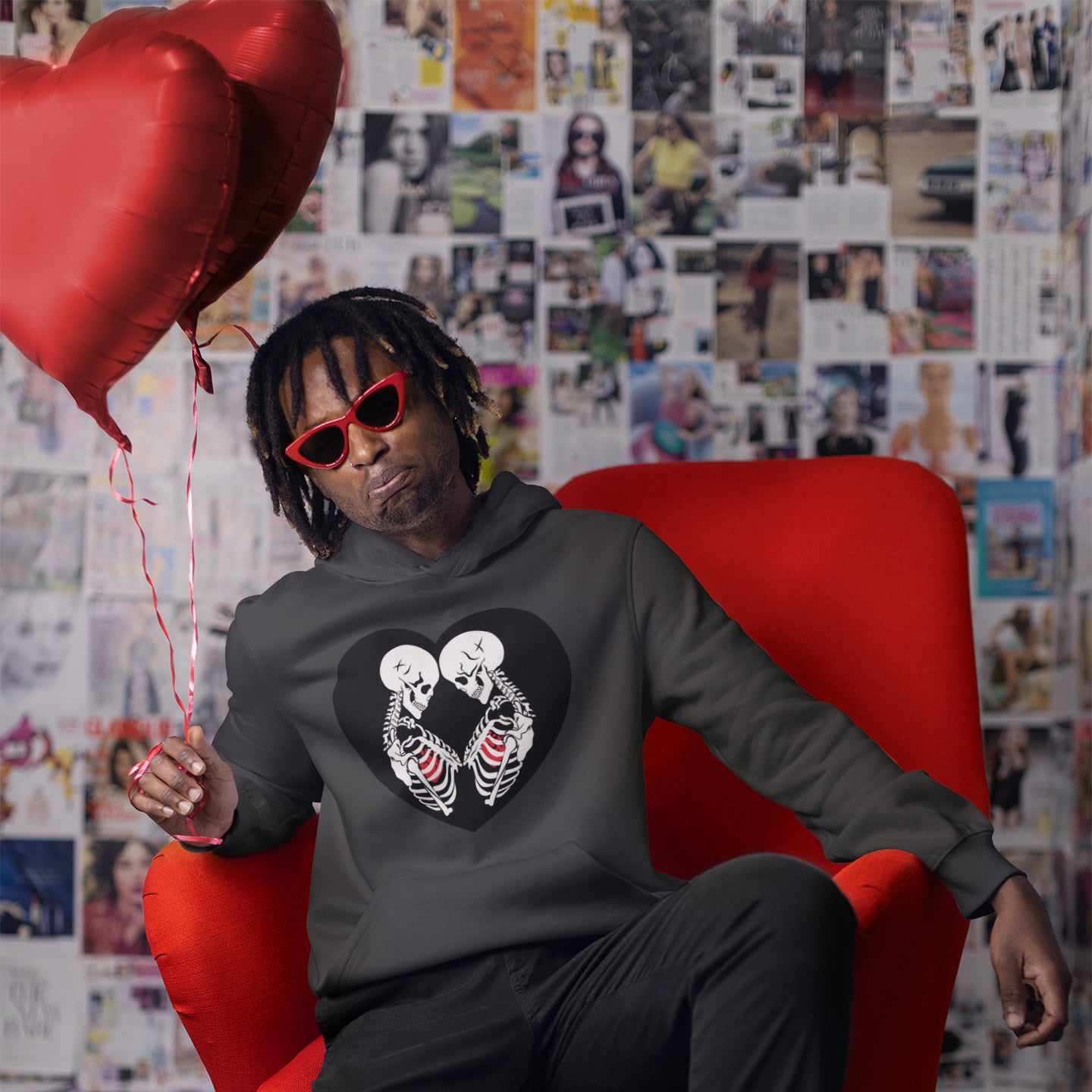 a man with a heart shaped balloon sitting in a red chair