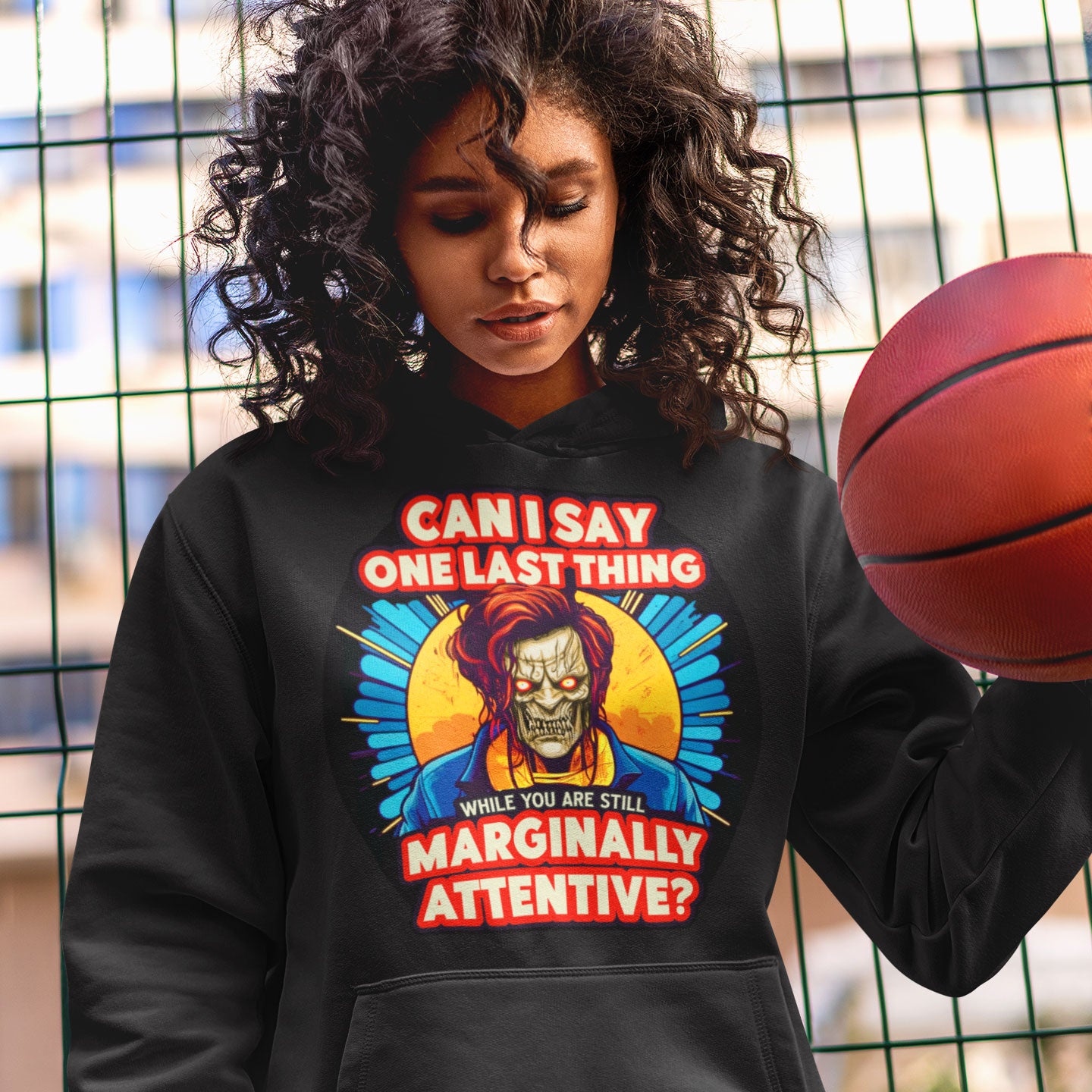 a woman wearing a black hoodie holding a basketball