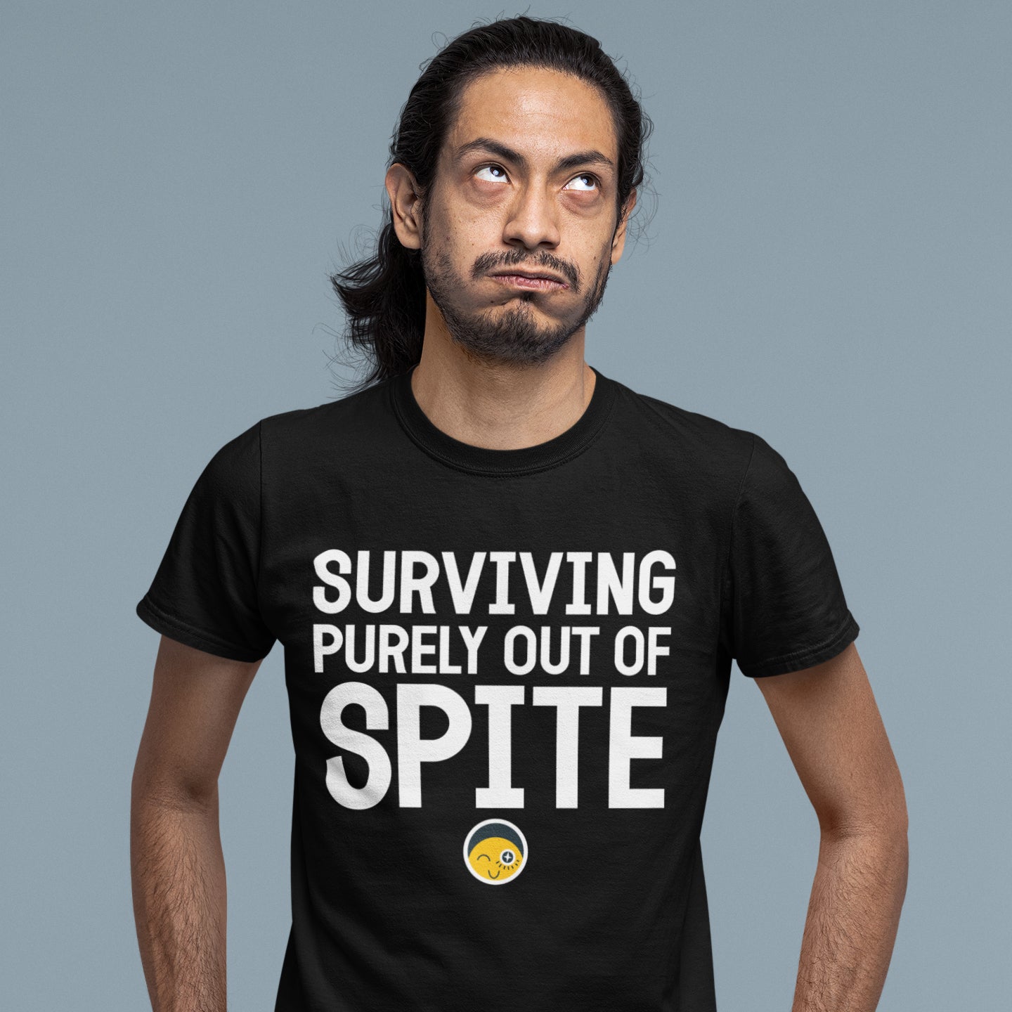 A man wearing a black t-shirt with the text "SURVIVING PURELY OUT OF SPITE" printed on it.