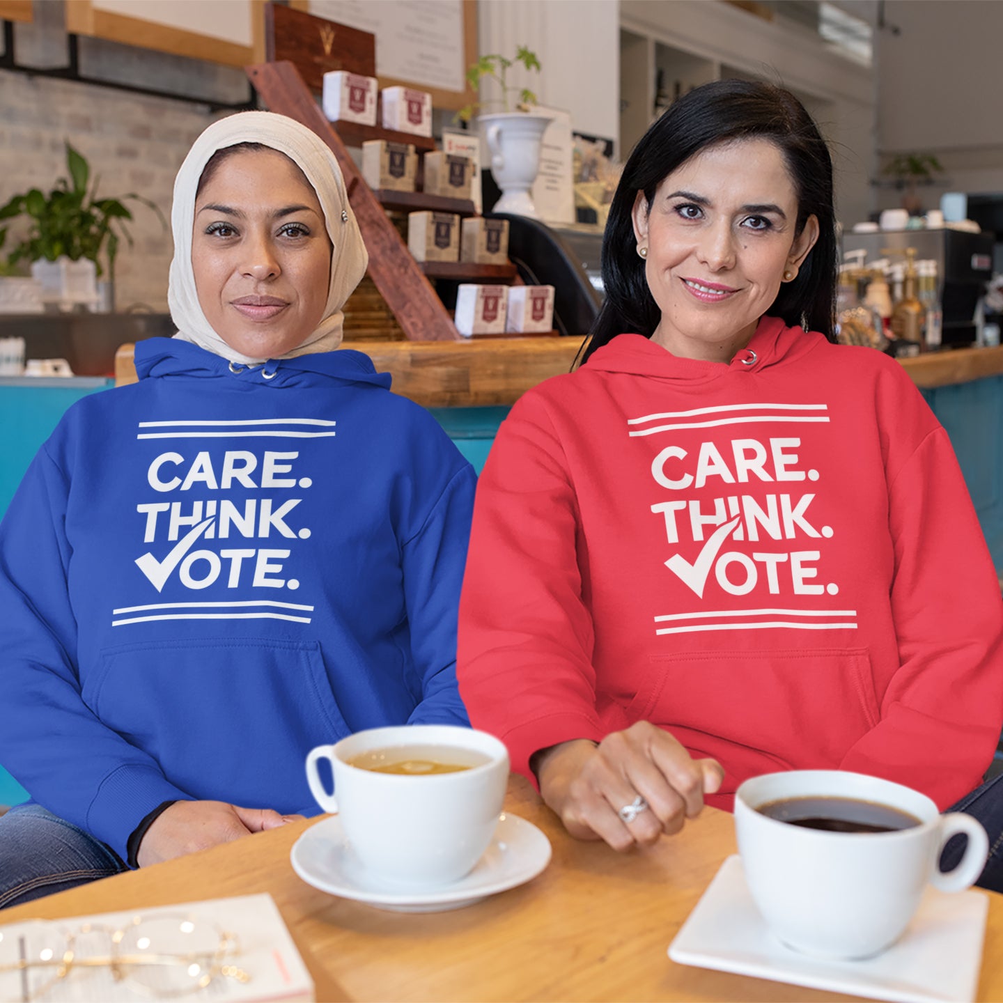 two women sitting at a table with cups of coffee