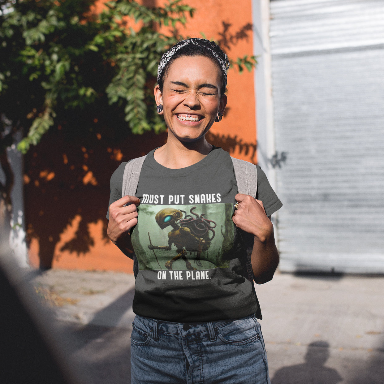 a woman holding a t - shirt with a picture of a spider on it