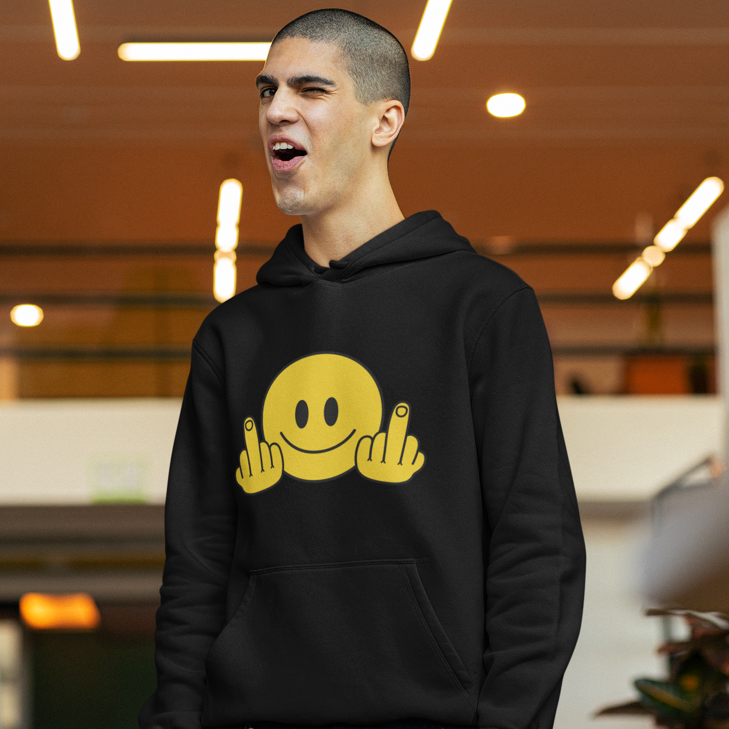 a young man wearing a black hoodie with a smiley face on it