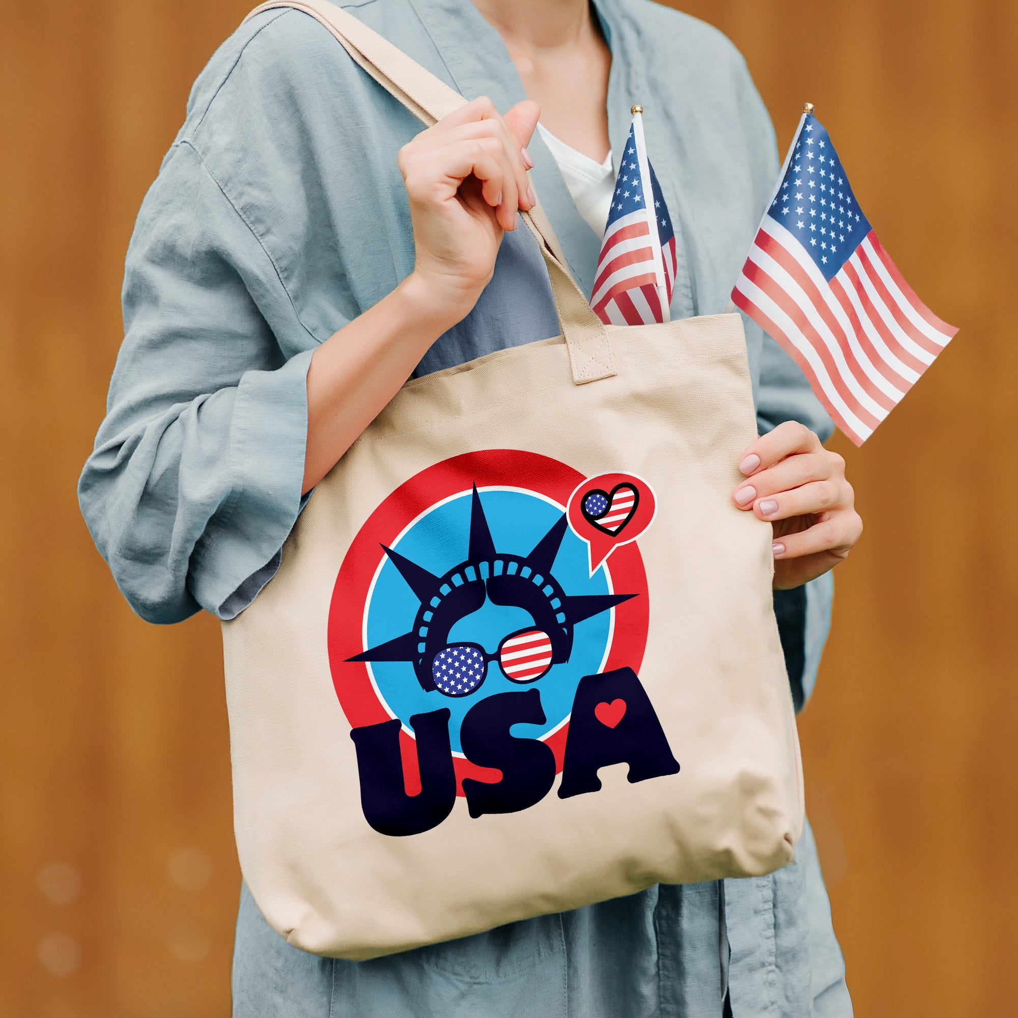 a woman holding a tote bag with the statue of liberty on it