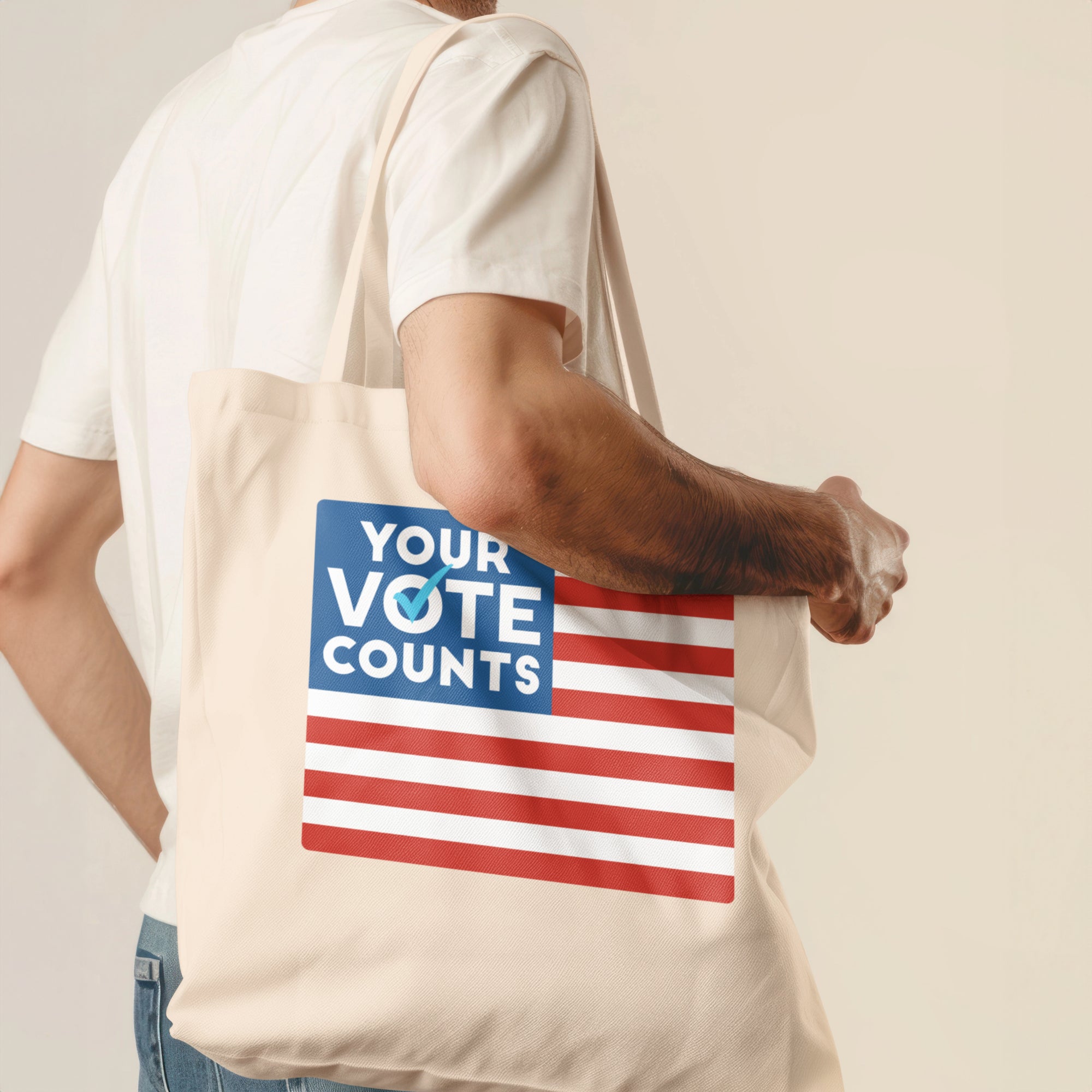 a man holding a tote bag with a vote counts sticker on it