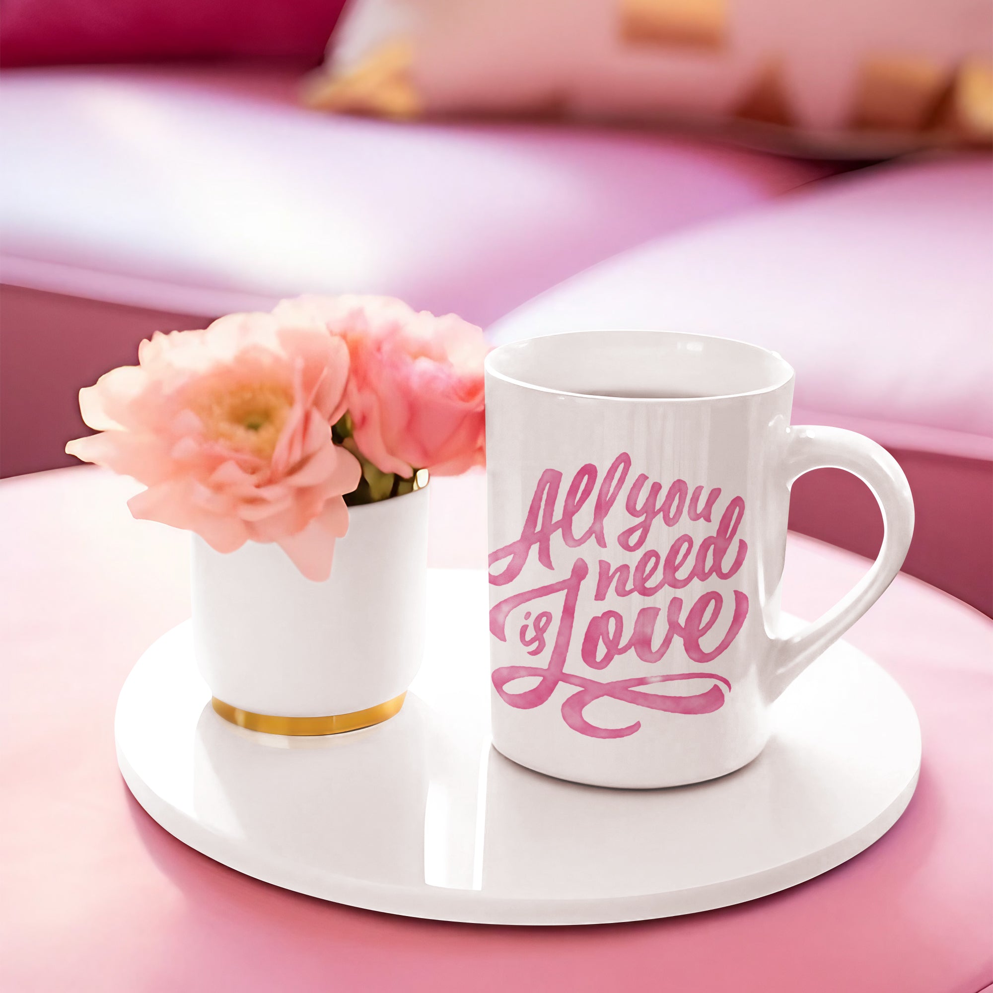 a white coffee cup with pink lettering on it next to a pink flower