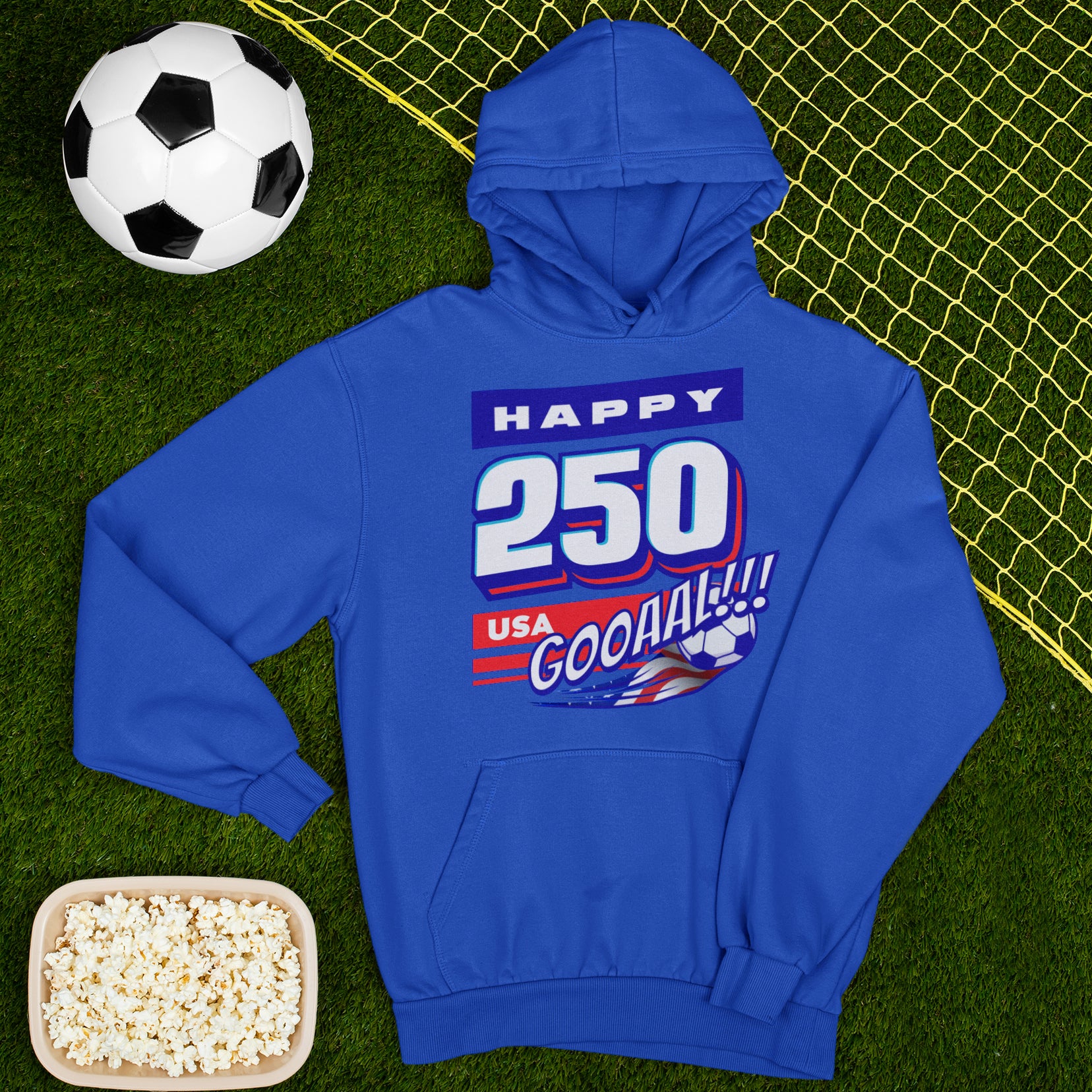 a blue hoodie sitting on top of a field next to a soccer ball