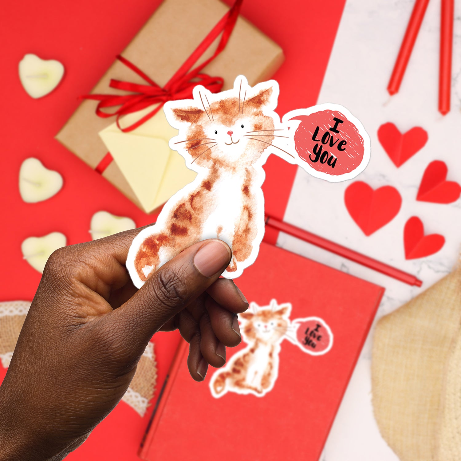 a hand holding a sticker of a cat