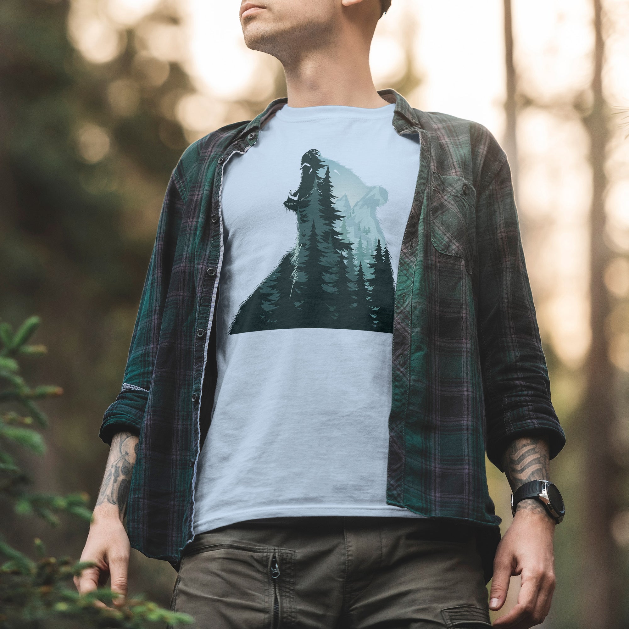 a man standing in the woods wearing a t - shirt with a bear on it