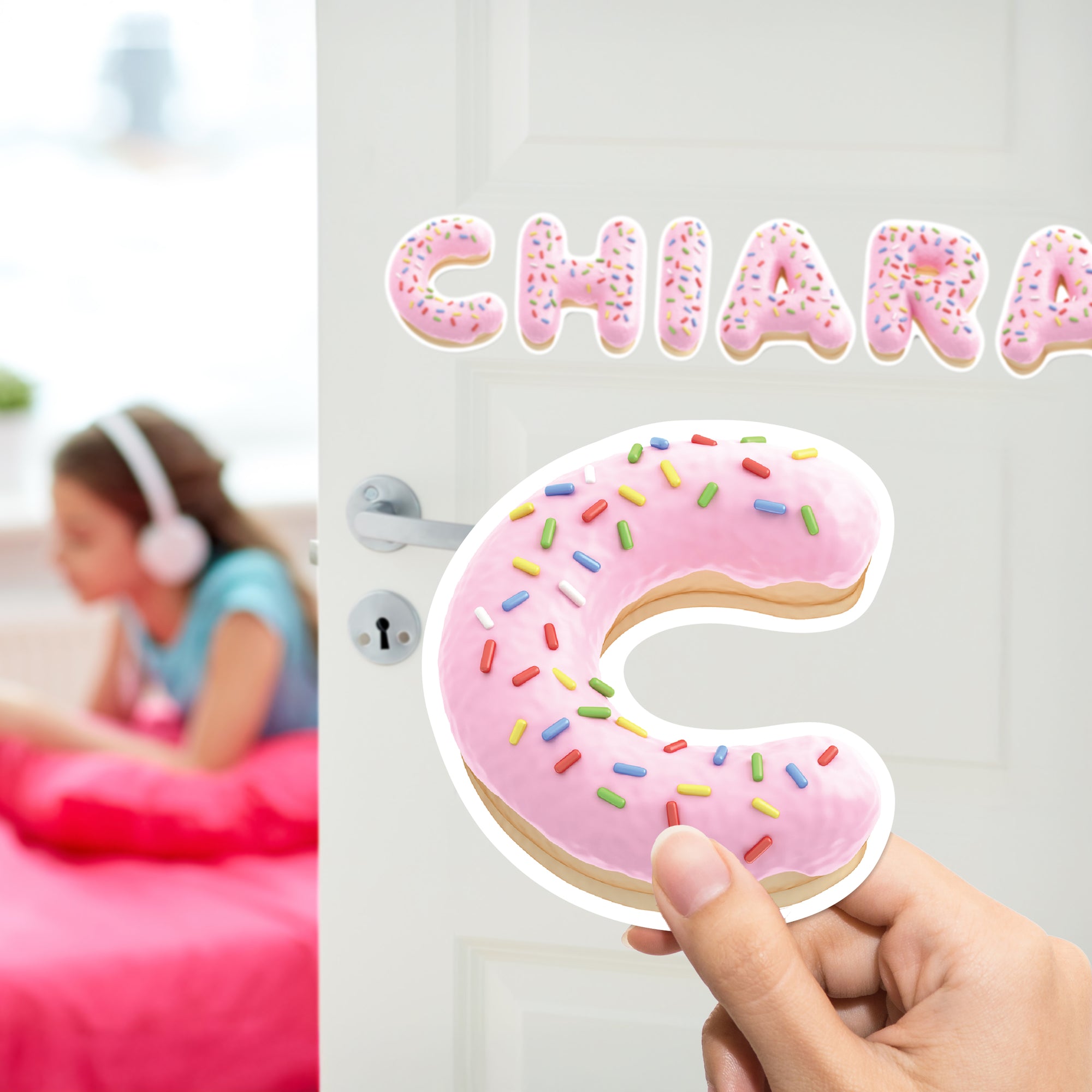 a person holding up a pink doughnut with sprinkles