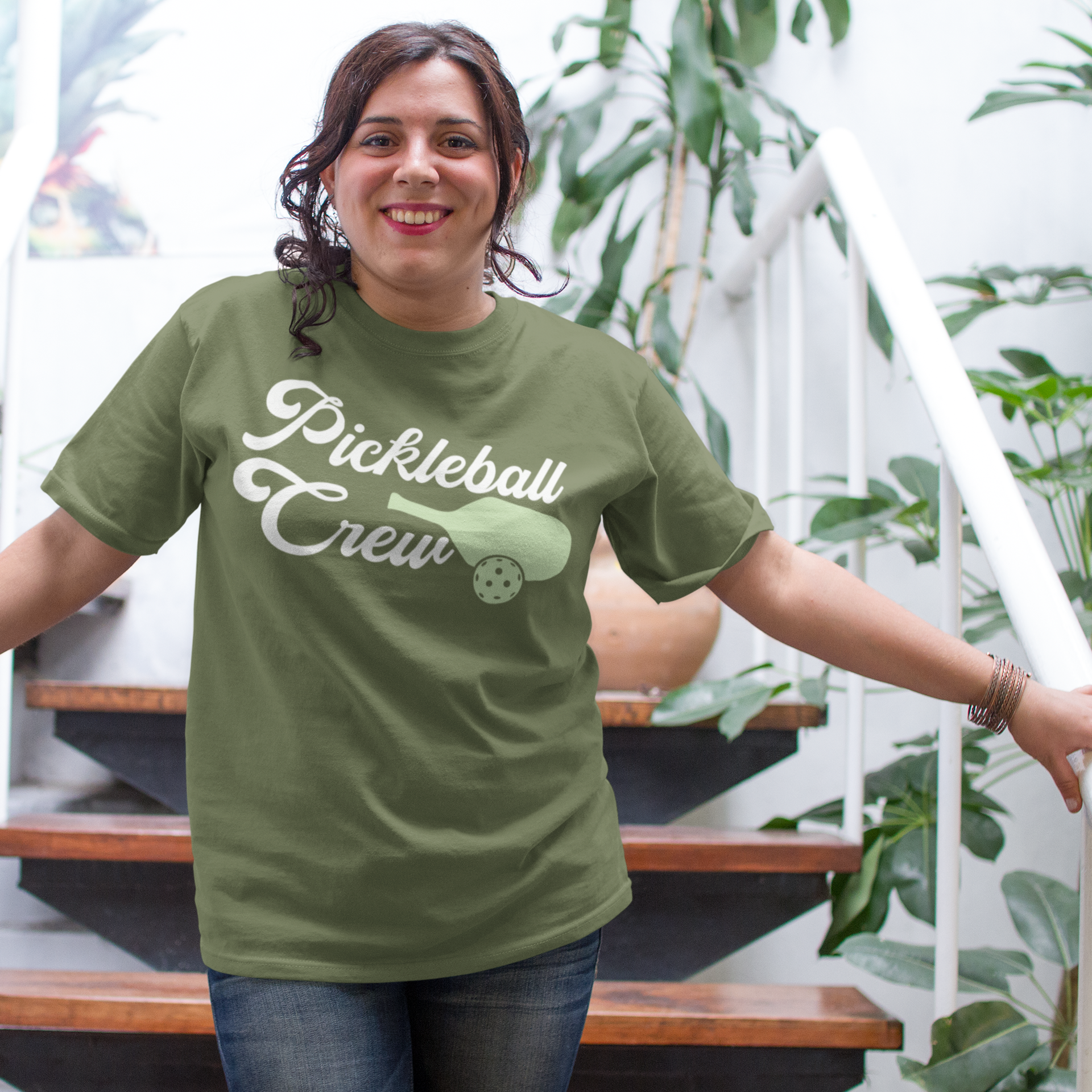 a woman in a green shirt is standing on a set of stairs