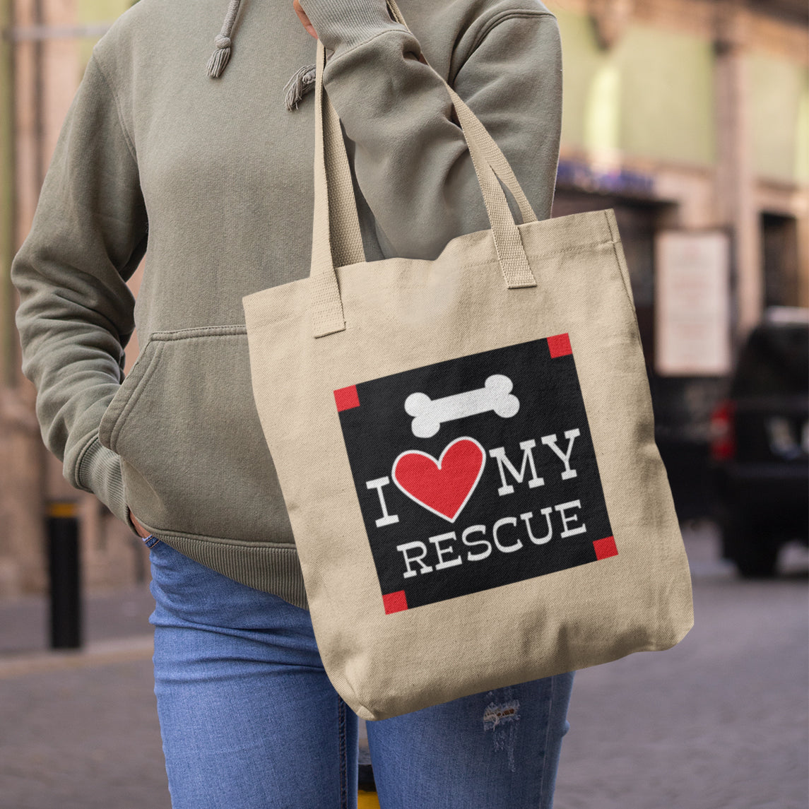 a woman carrying a bag that says i love my rescue