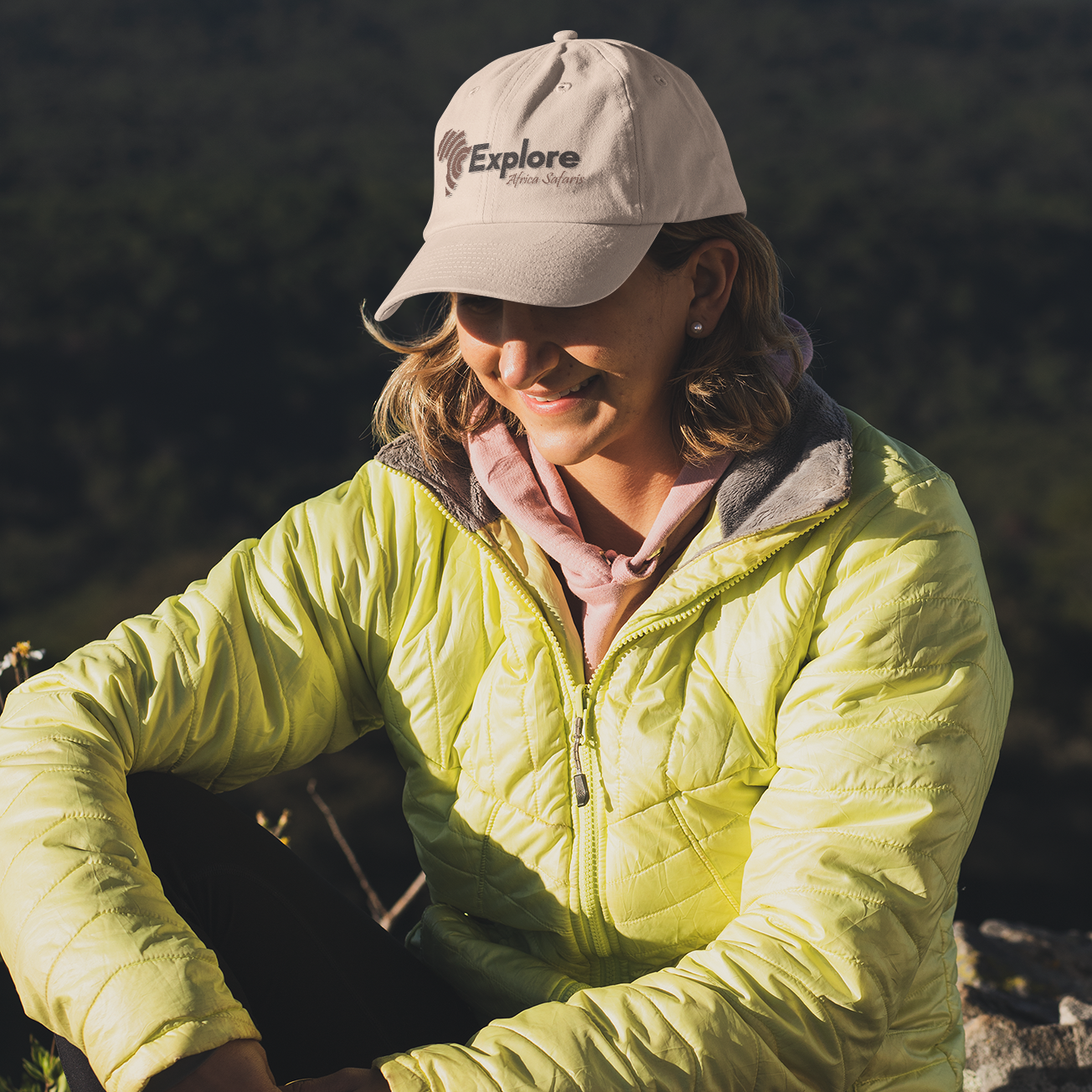 a woman sitting on a rock with a hat on