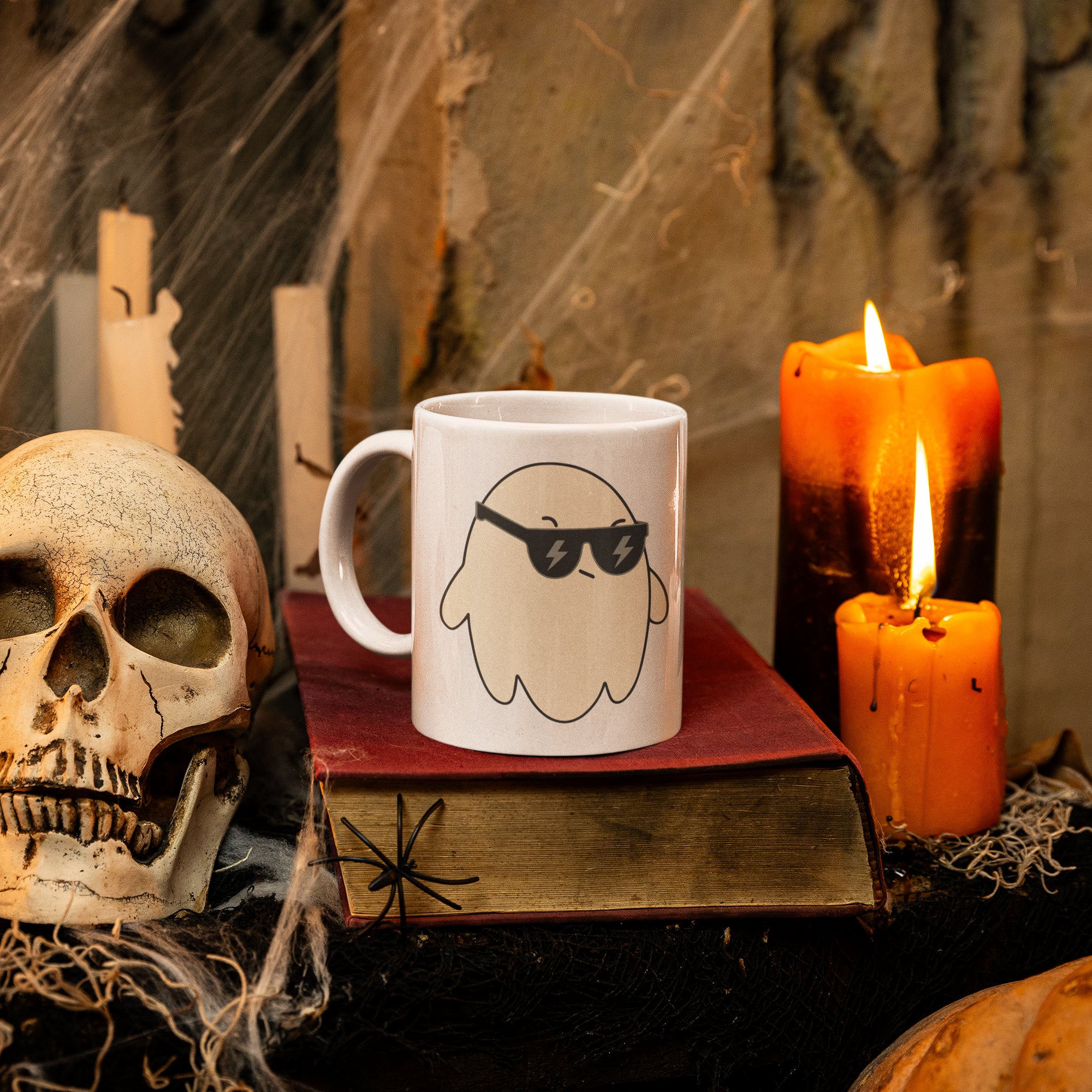 a skull sitting on top of a book next to a candle