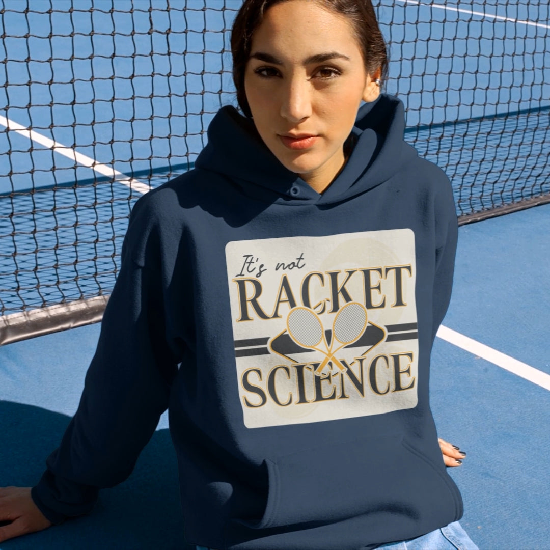 a woman sitting on a tennis court wearing a hoodie