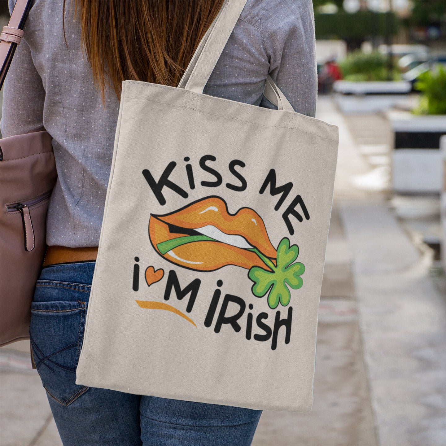 a woman carrying a tote bag that says kiss me i'm irish