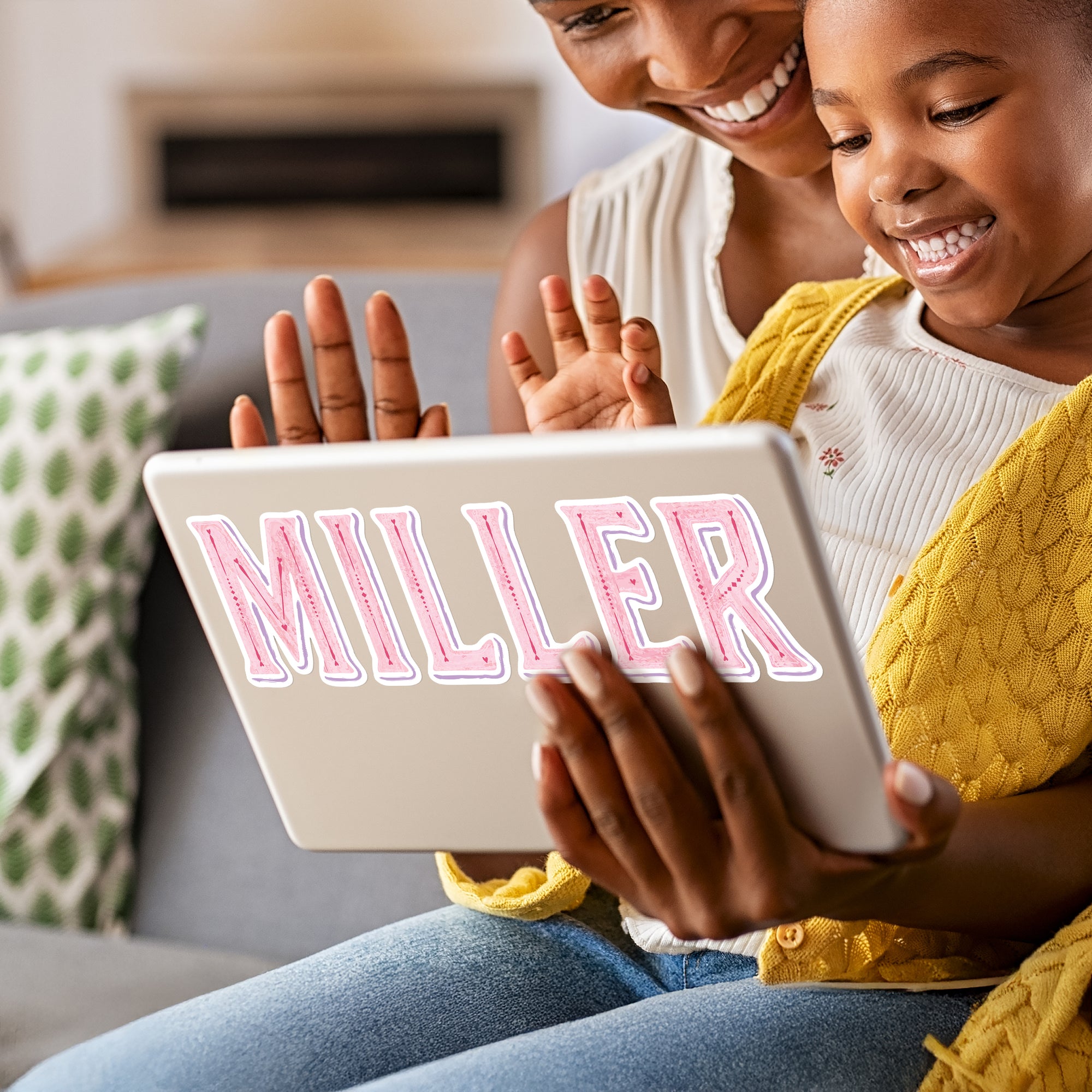 a woman and a young girl sitting on a couch looking at a tablet