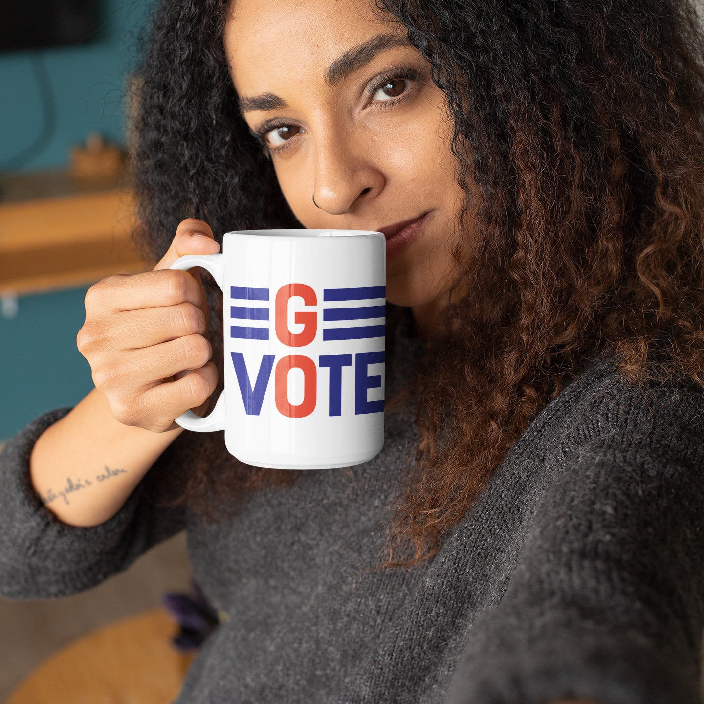 a woman holding a coffee mug with the word go vote on it