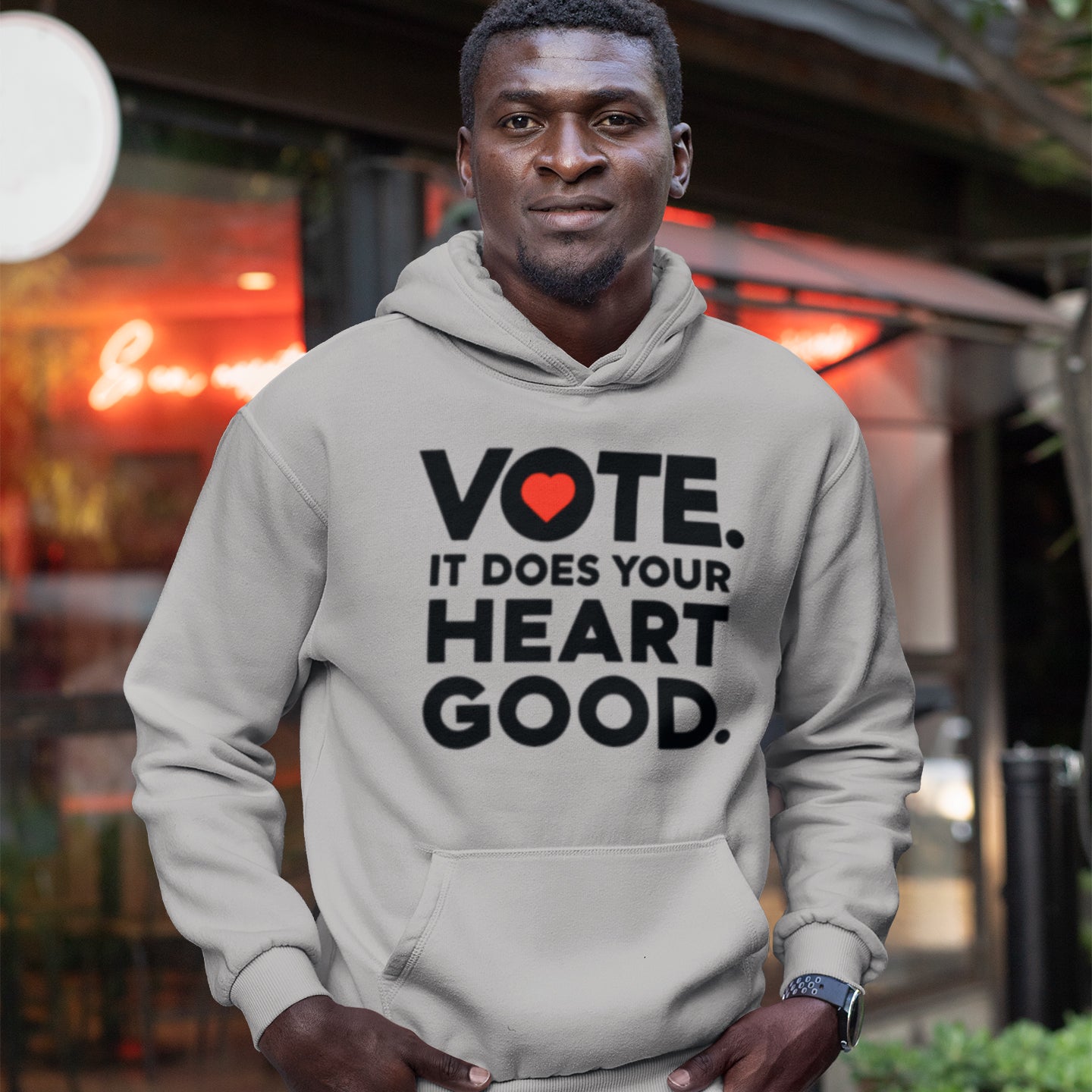 a man wearing a vote it does your heart good hoodie