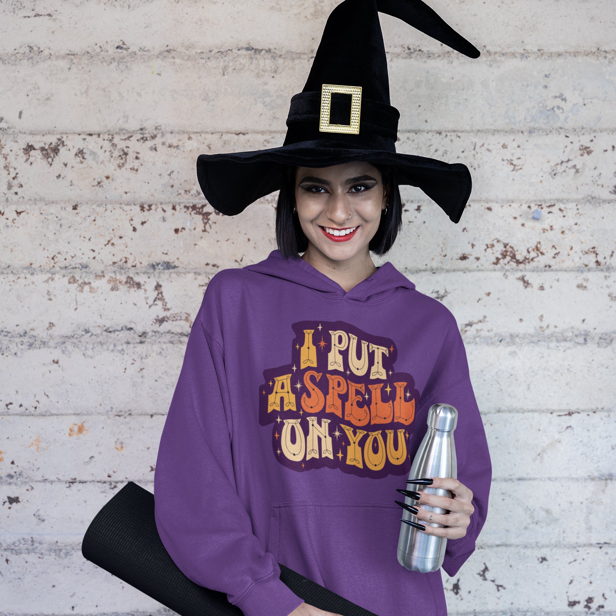 a woman wearing a purple hoodie with a witch hat