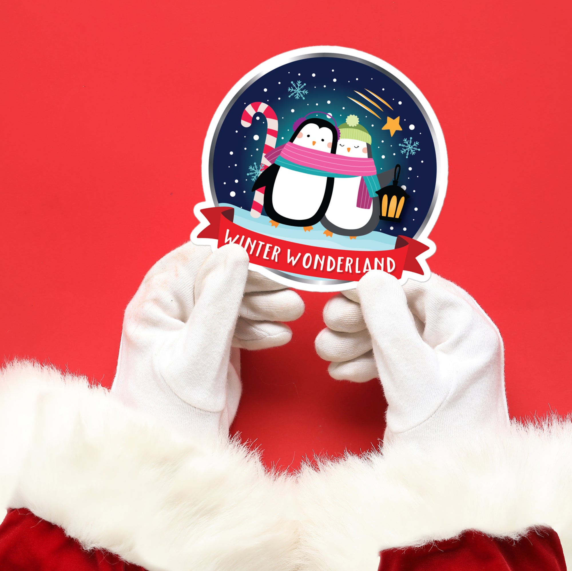 a person in a santa claus outfit holding a sticker with a penguin on it