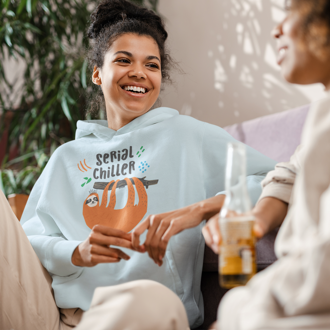 a woman sitting on a couch holding a drink and smiling