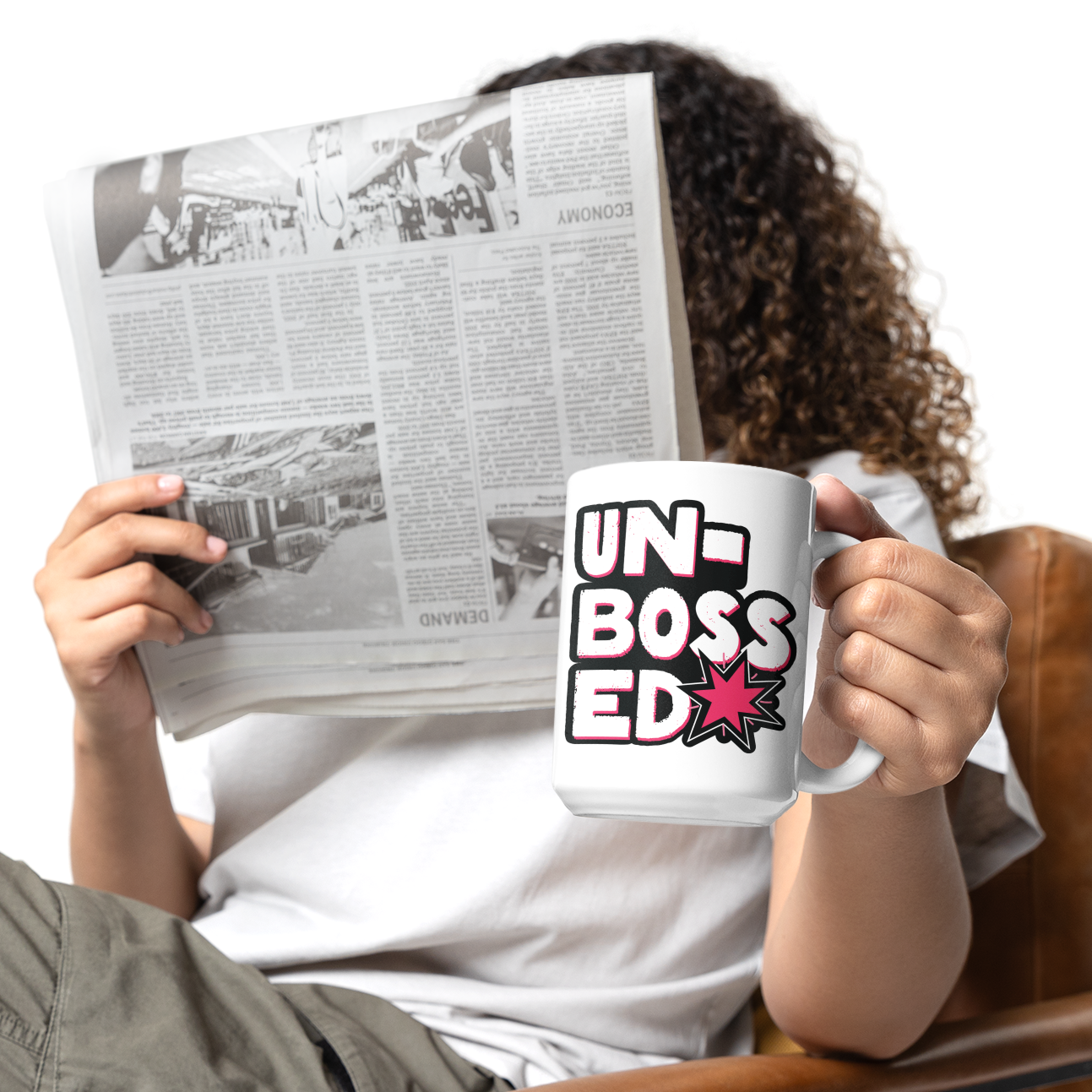 a woman reading a newspaper while holding a coffee mug