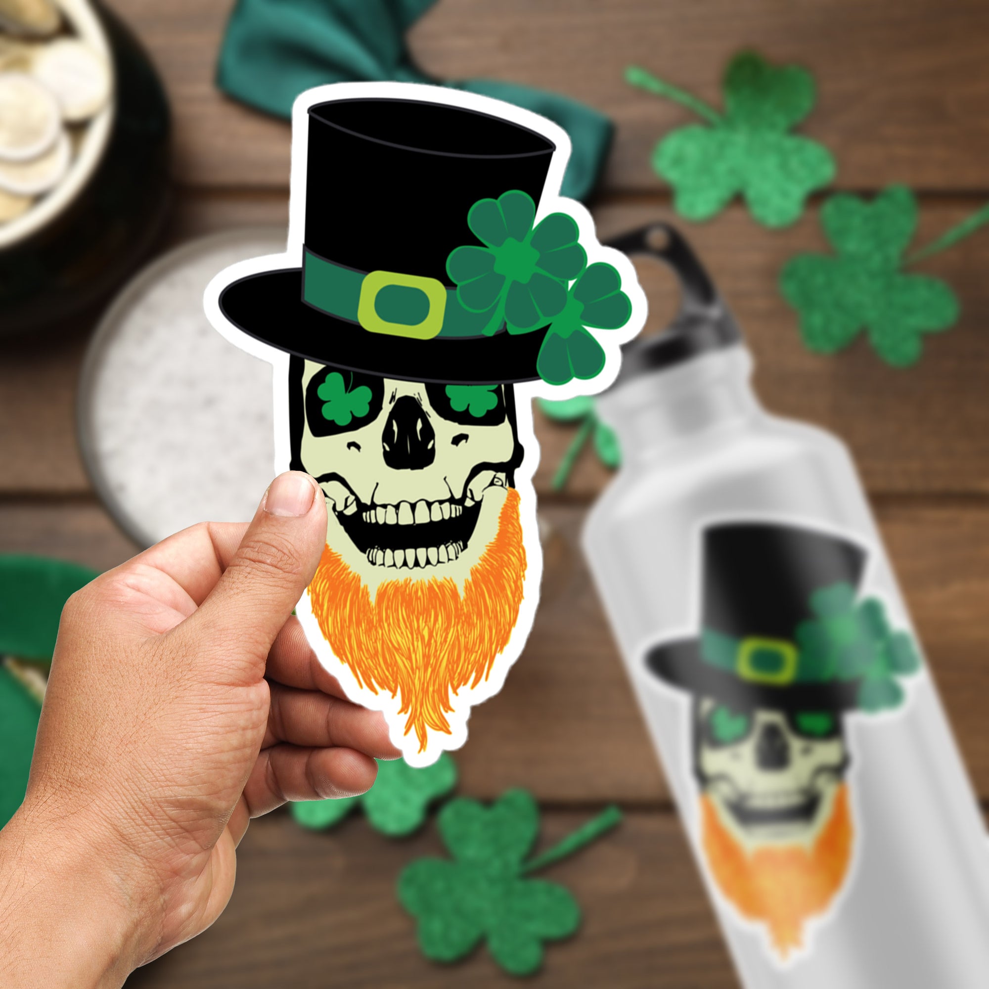 a hand holding a sticker of a skull wearing a green hat