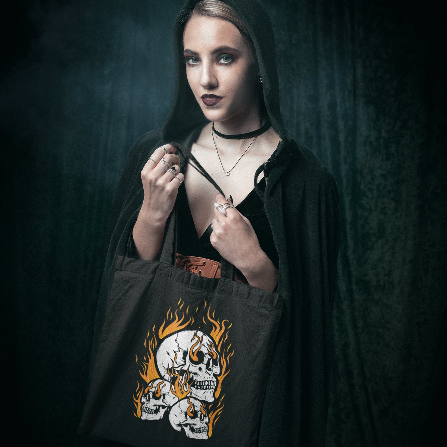 a woman holding a black bag with a skull on it