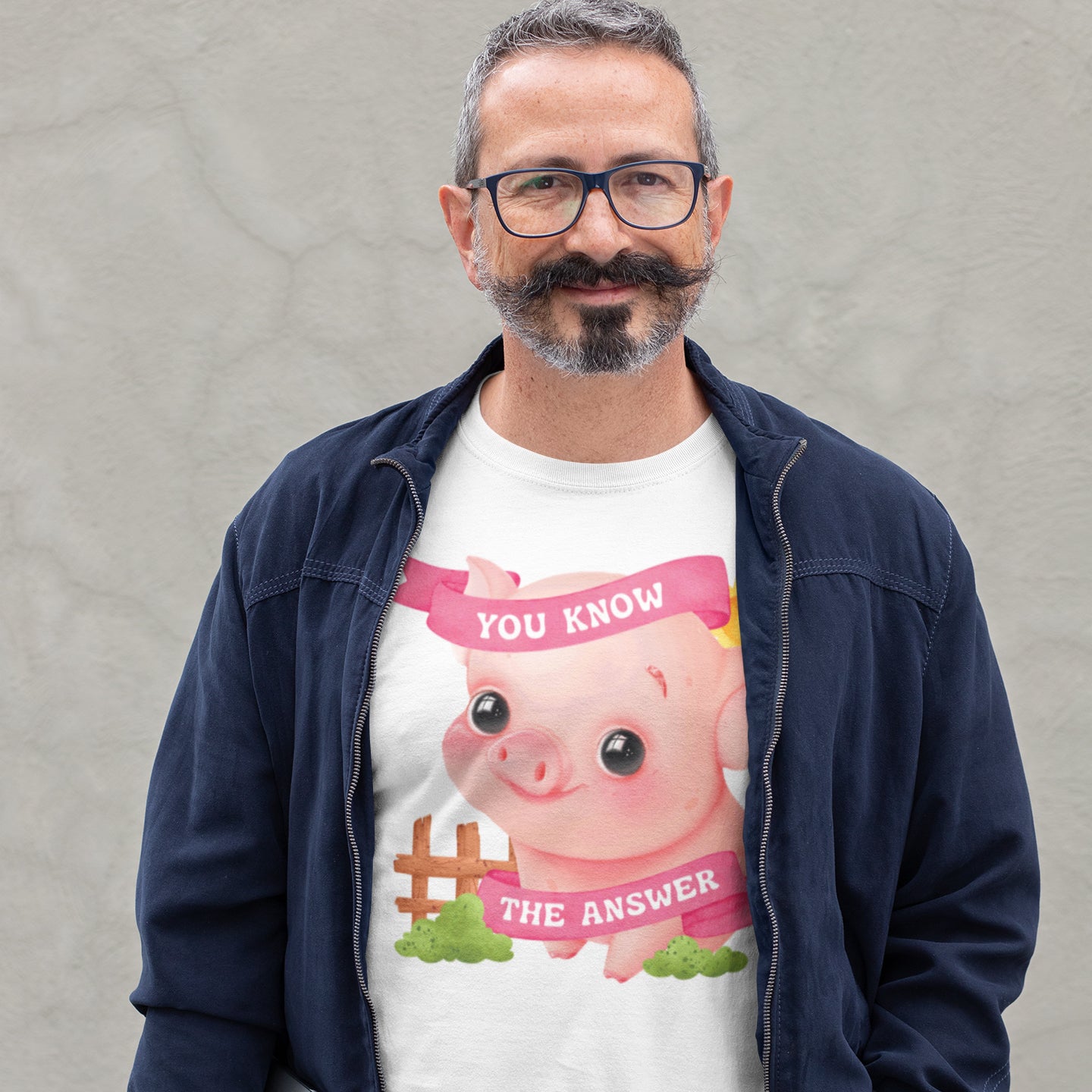 A man wearing a white t-shirt with a cartoon pig and the text "YOU KNOW THE ANSWER" printed on it.