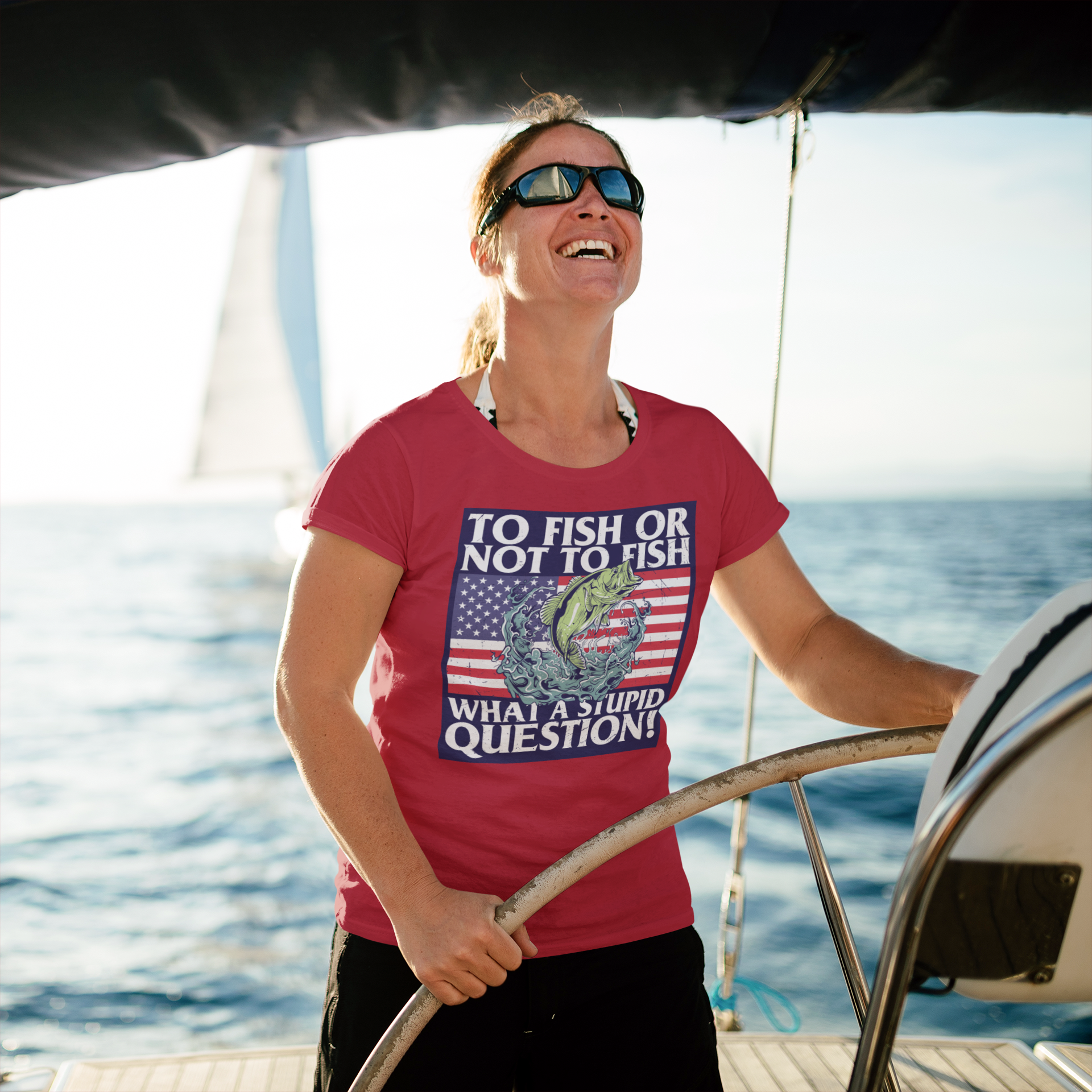 a woman wearing a red shirt and sunglasses on a boat