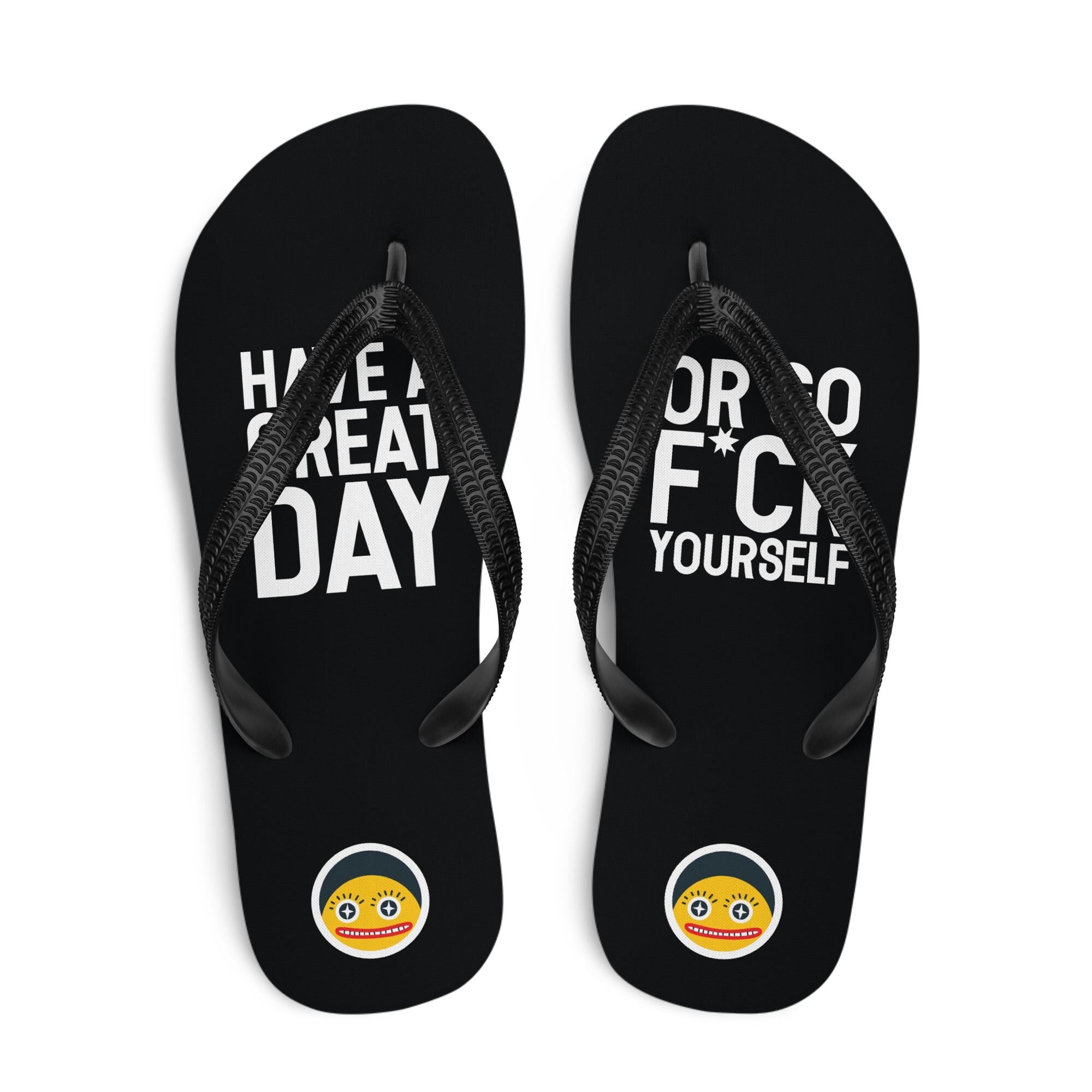 A pair of black flip-flops with white text and a yellow smiley face sticker.