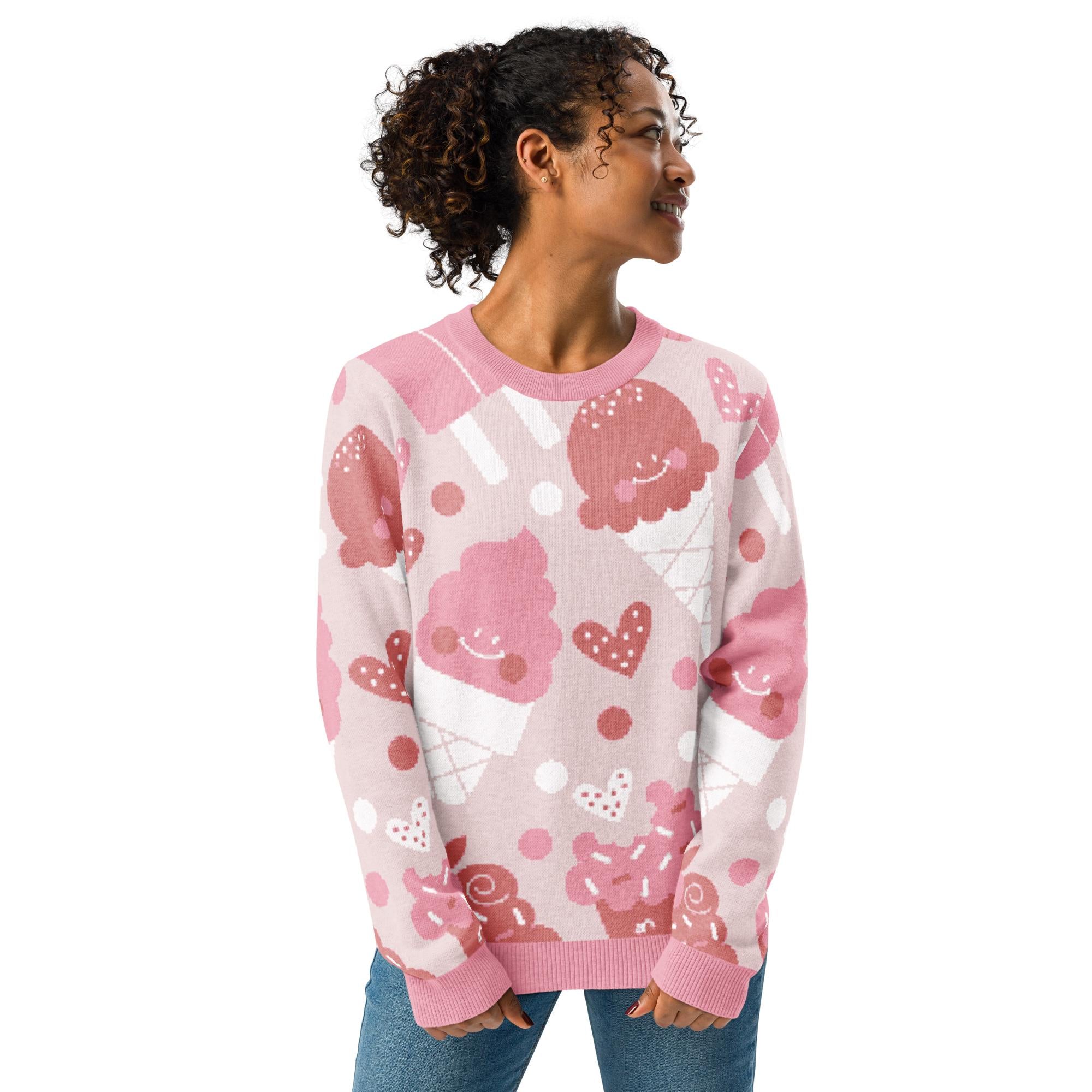 A woman wearing a pink sweater with a playful pattern of ice cream cones and other desserts.