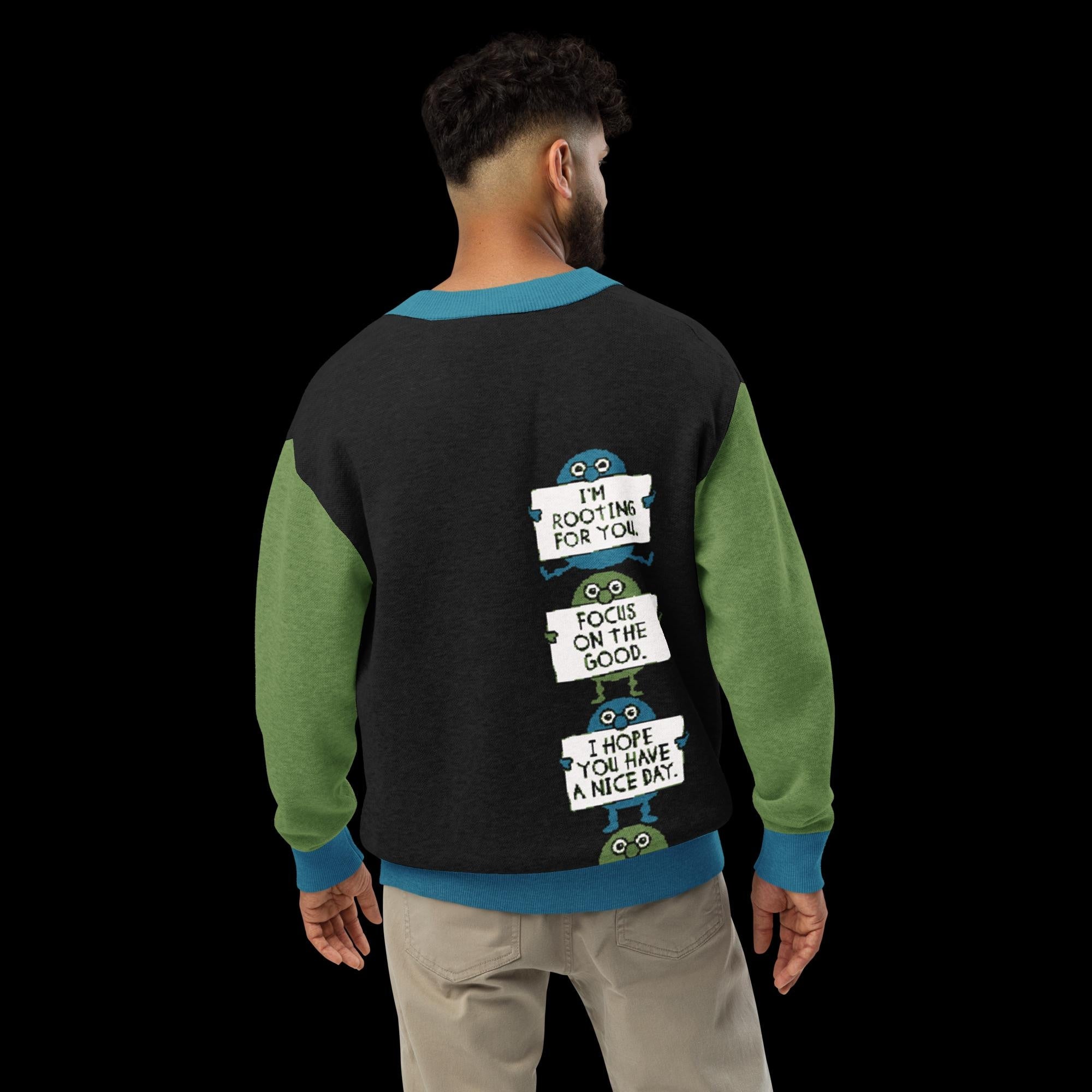 a person wearing a black and green sweater with a humorous text printed on the back.