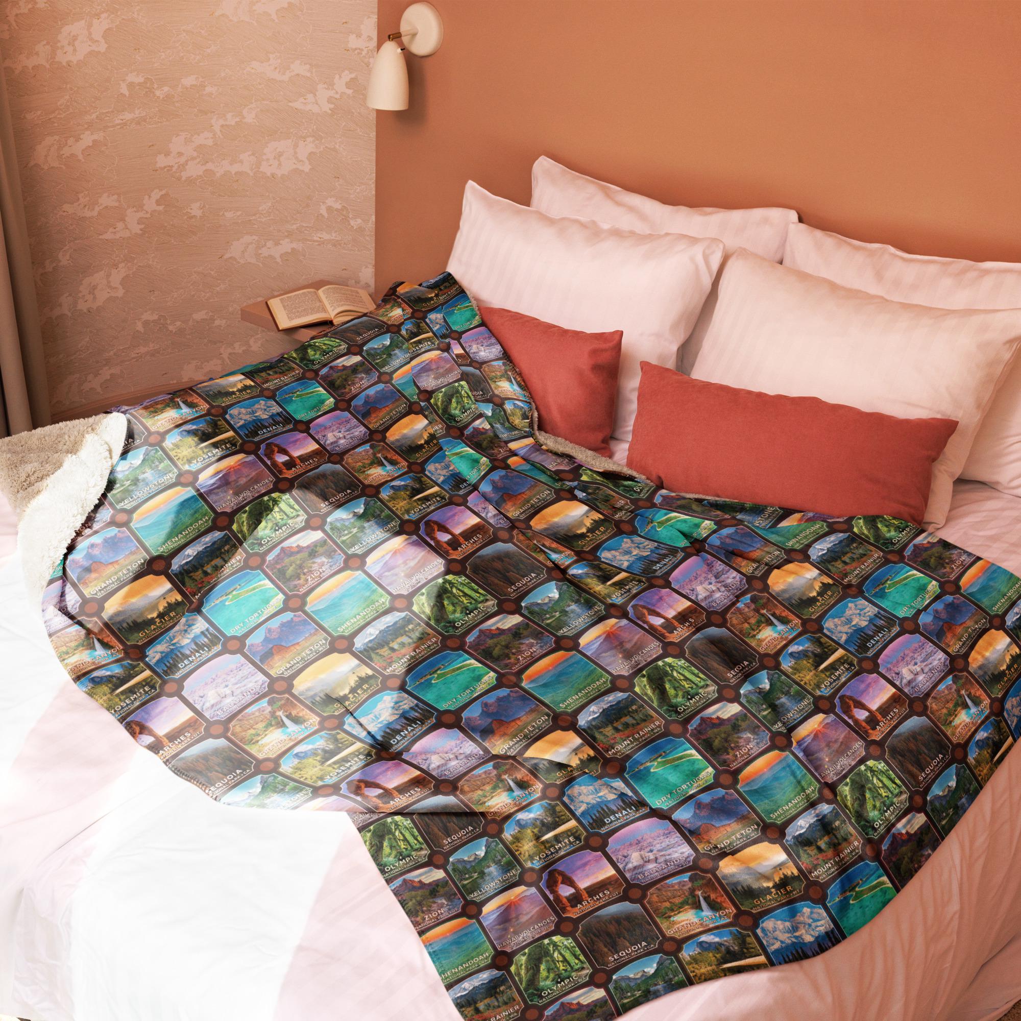 a cozy bedroom scene with a bed covered in a colorful, patterned blanket featuring various landscapes and scenes.