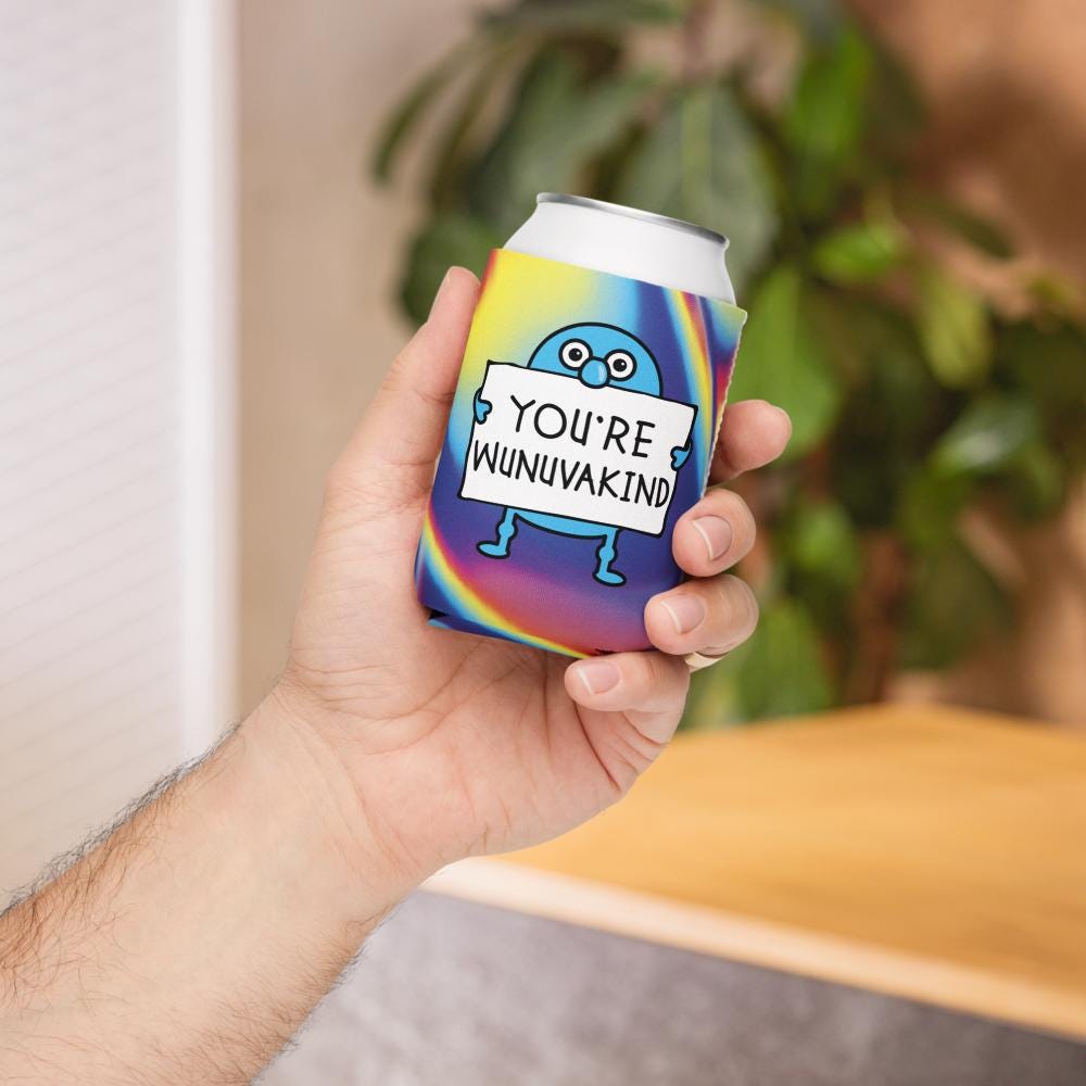 A person's hand holding a colorful can with a rainbow-colored character and text on it.