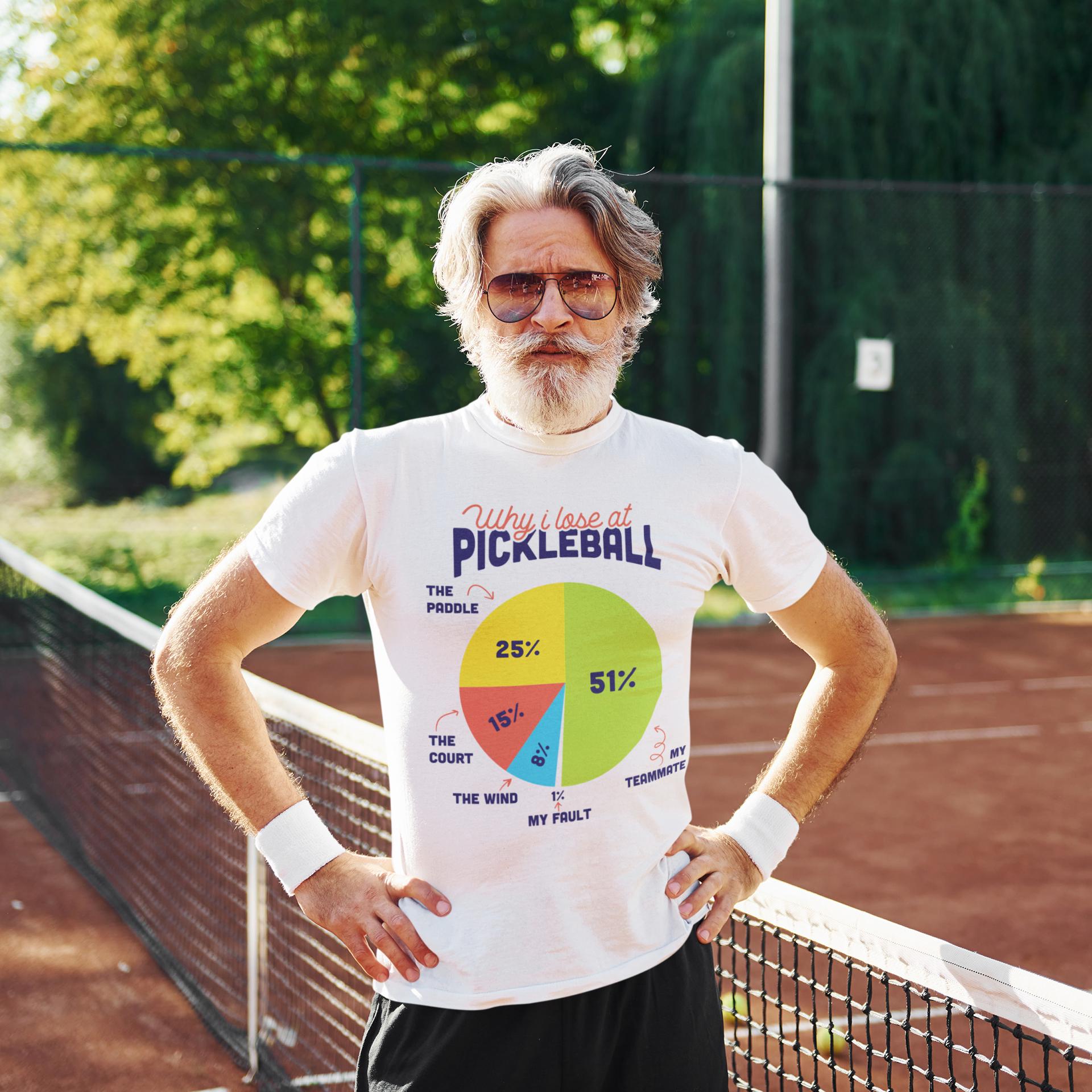 A man wearing a white t-shirt with a colorful pie chart graphic printed on it, standing on a tennis court.