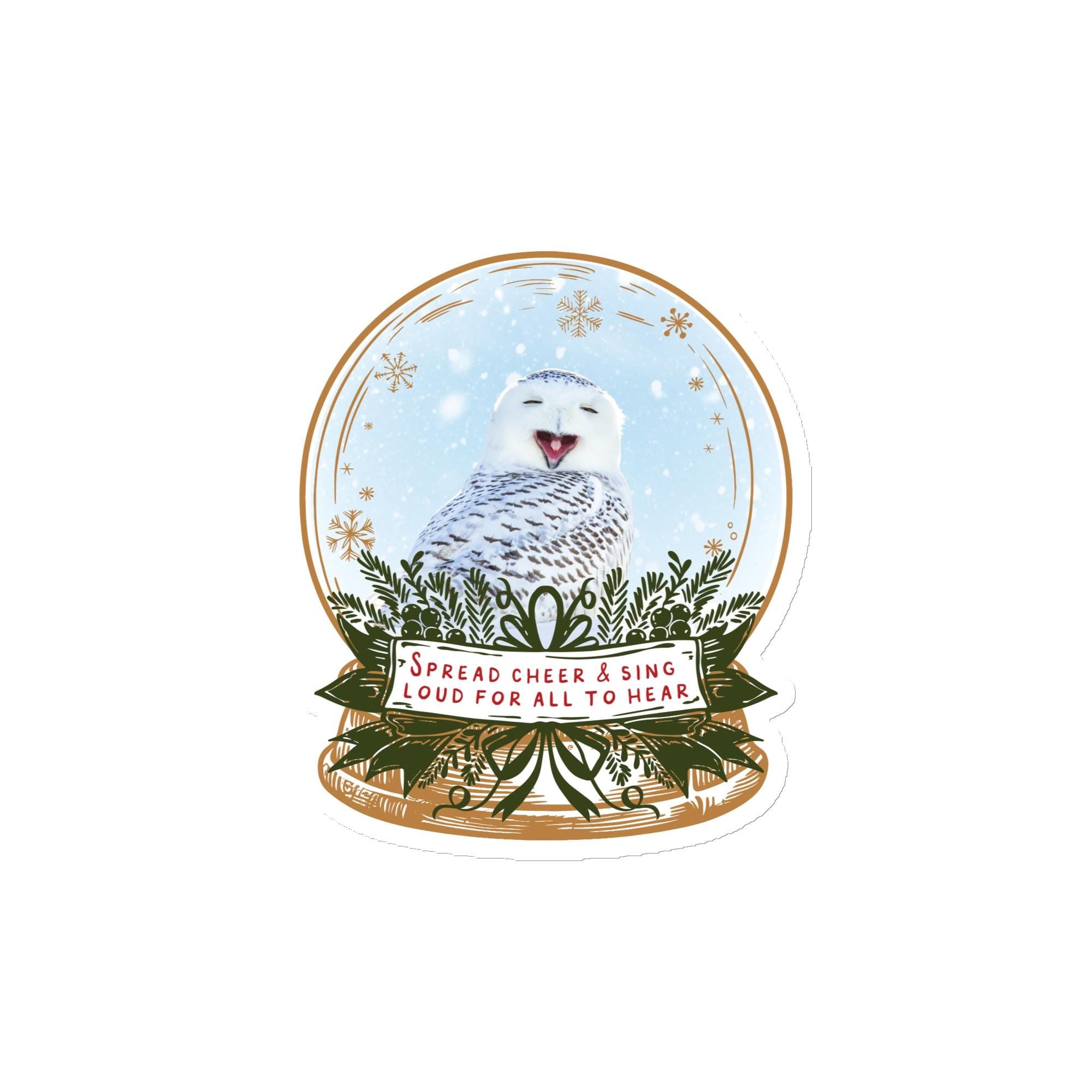 A snow globe containing a white owl with a cheerful expression, surrounded by snowflakes and greenery. The text on the snow globe reads "Spread cheer & sing loud for all to hear".