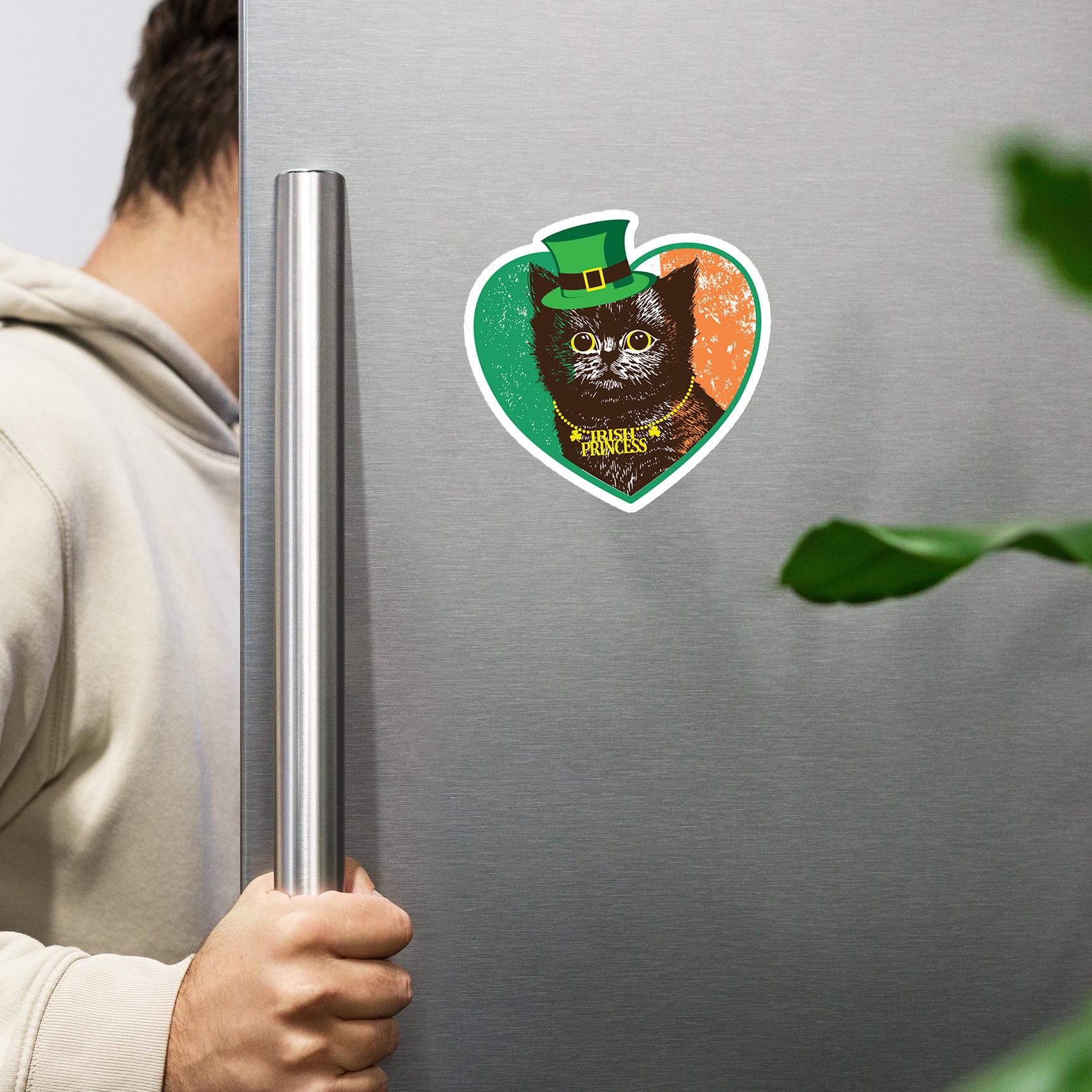 A person is holding a refrigerator door with a heart-shaped sticker featuring a cat wearing a green hat.