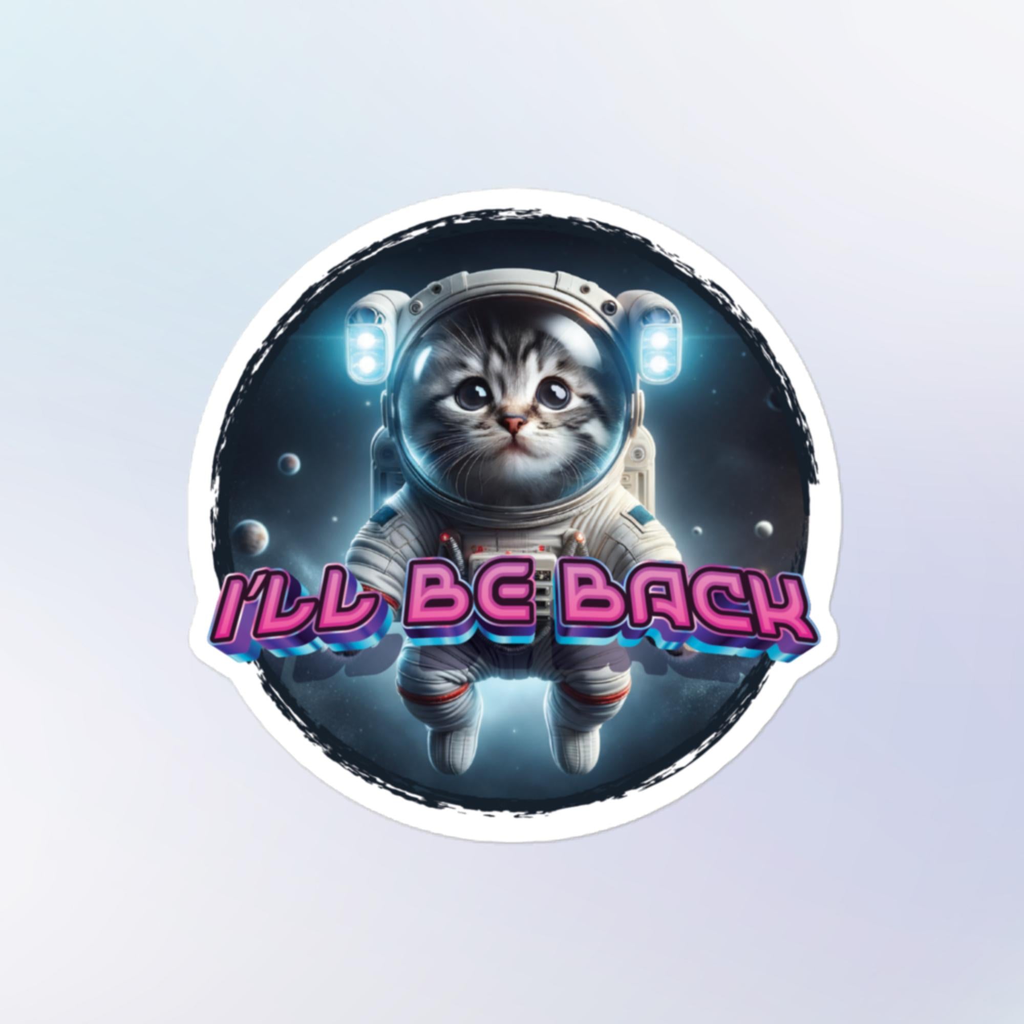 Sticker Shape: Round. Design: Astronaut body with large doe-eyed cat face floating in space with pink text that reads "I'll Be Back"